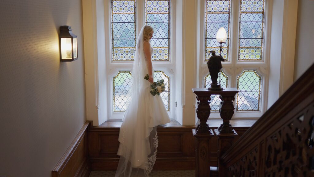 Bride Stood In Clevedon Hall Window and Staircase