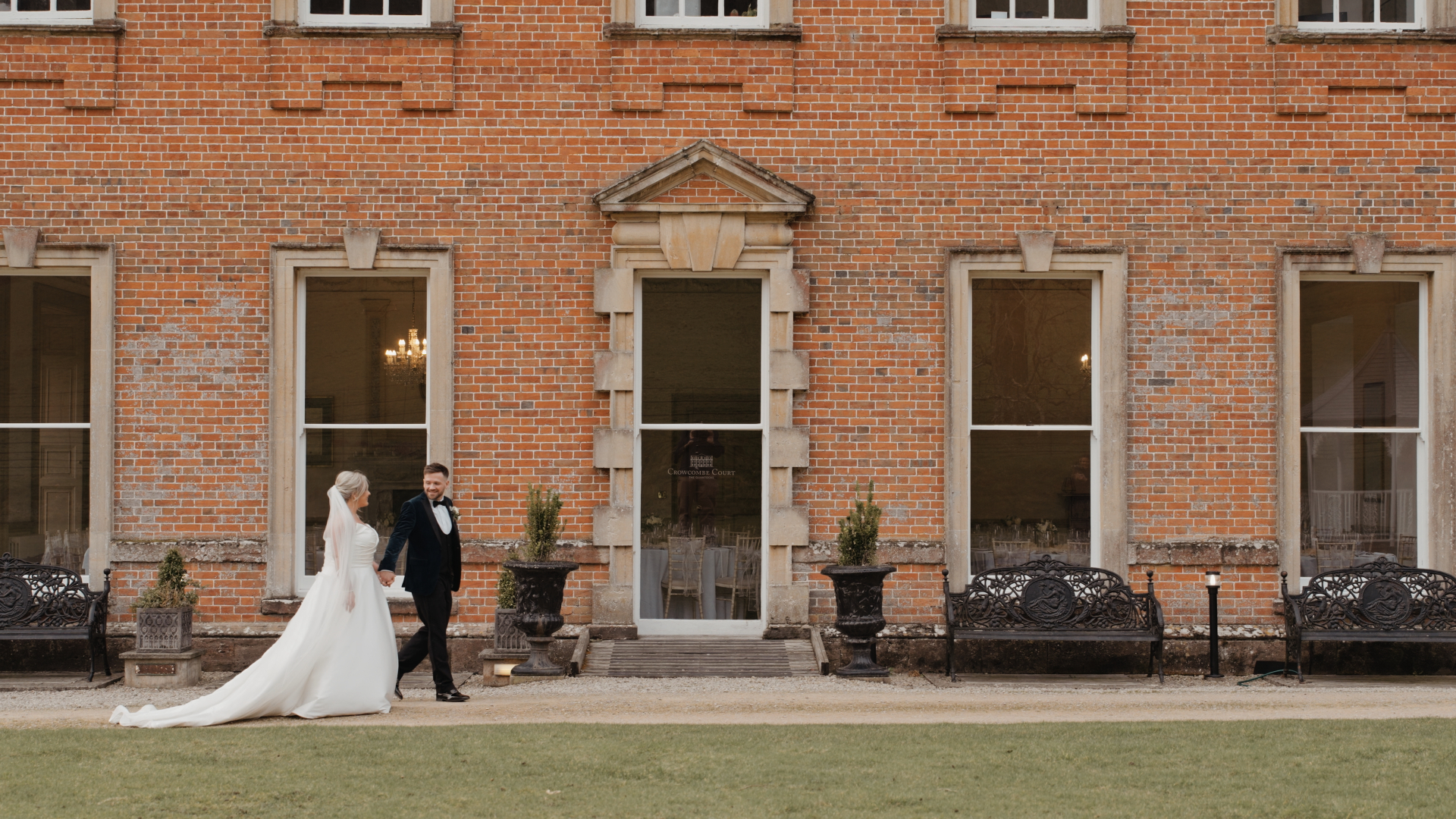 A stunning view of Crowcombe Court’s historic facade with a newlywed couple in the foreground.