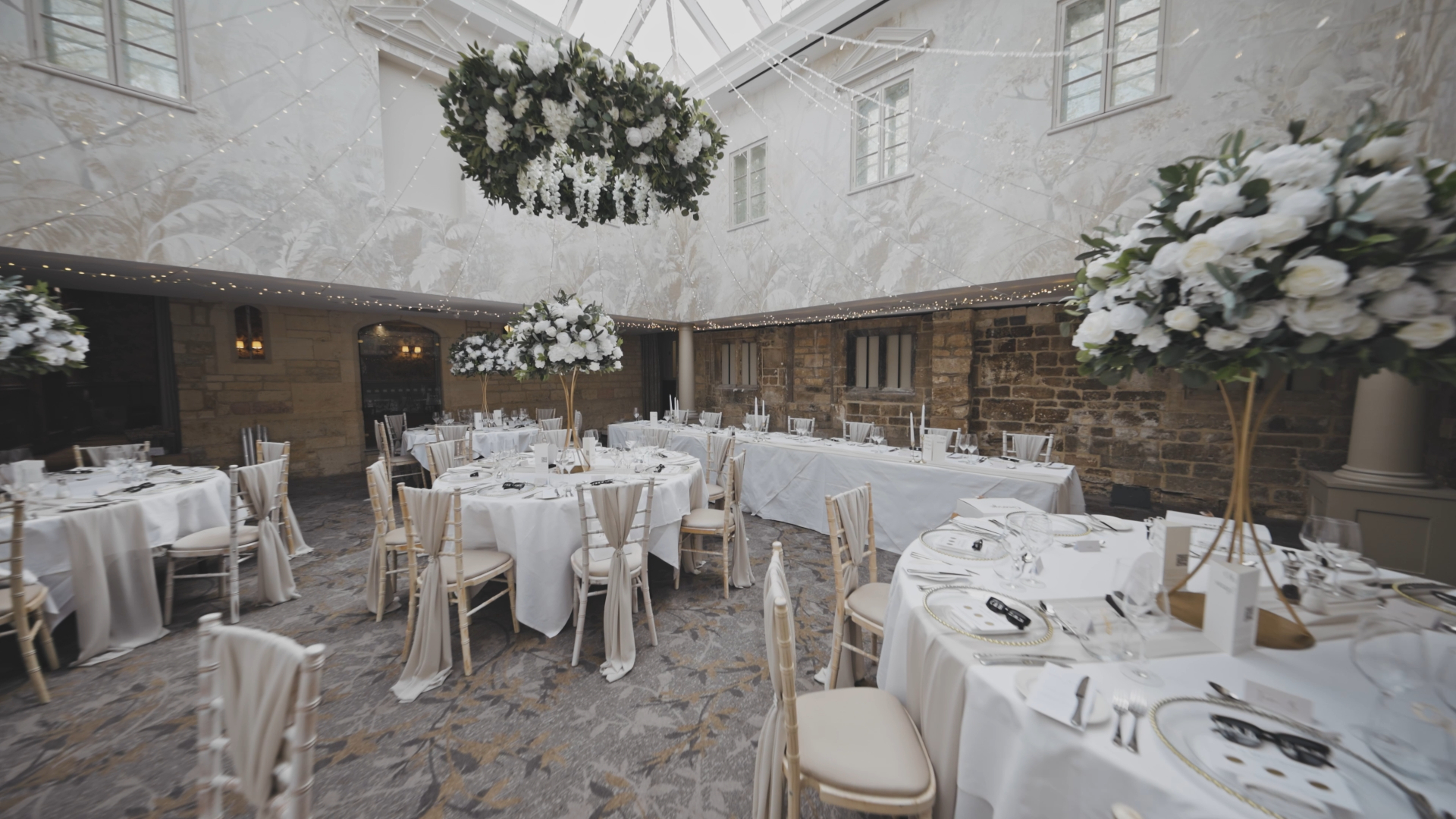 Wedding reception table setup featuring textured cloths and draped fabric from the ceiling, highlighting one of the key wedding trends in 2025, with rich textures adding depth and elegance to the decor.