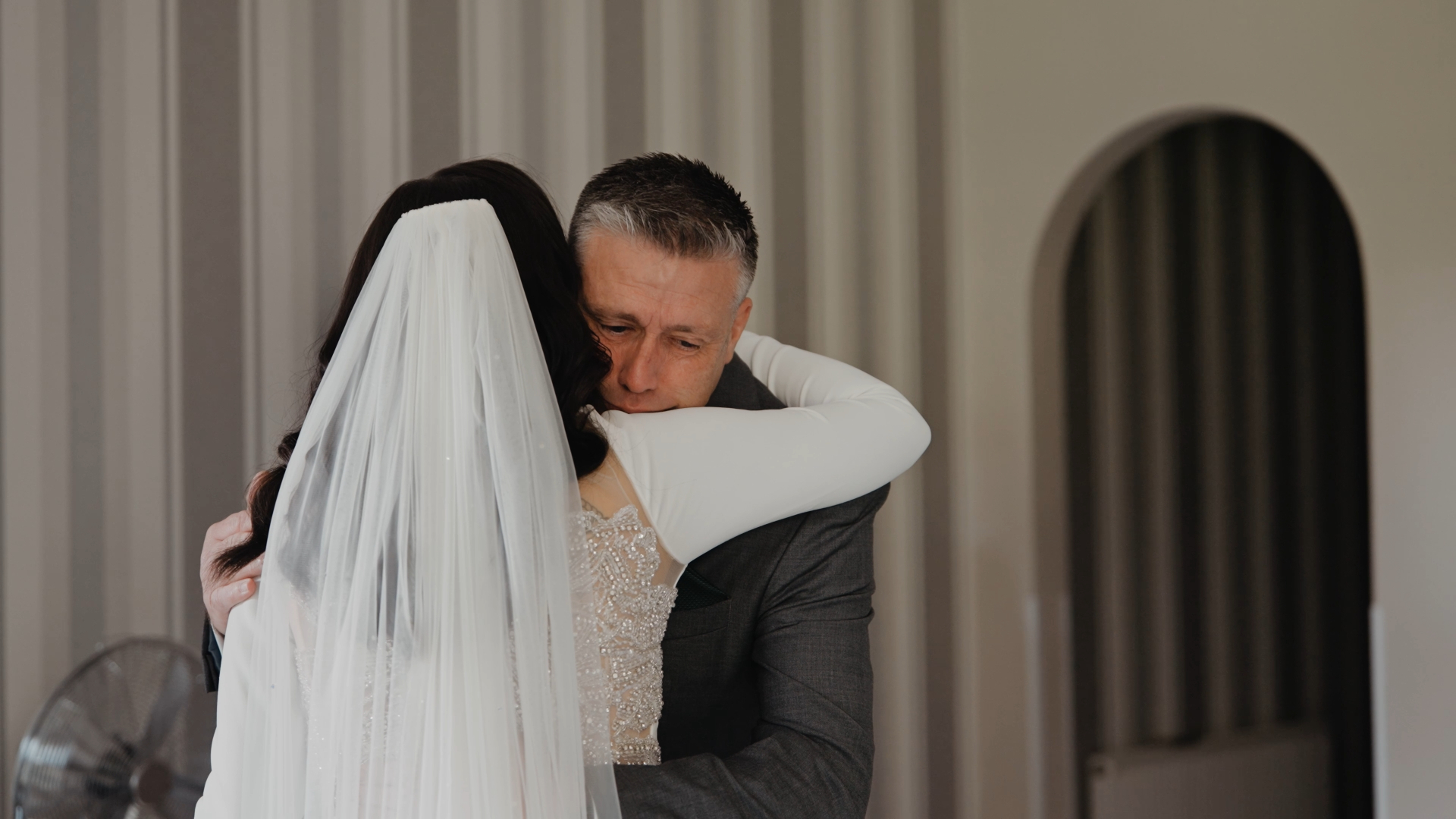 Emotional bride's dad hugging bride after the first look moment