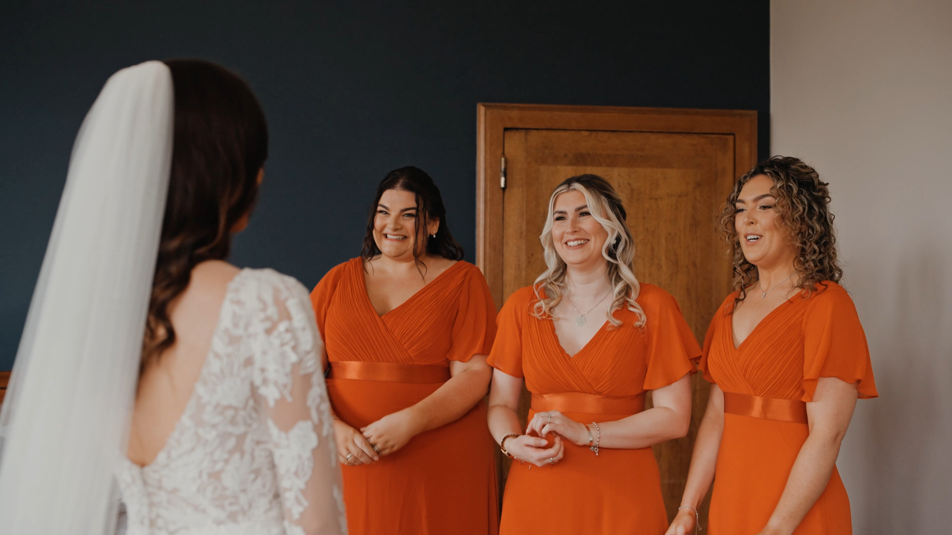  Bridesmaids smiling at bride during first look, showcasing wedding trends 2025