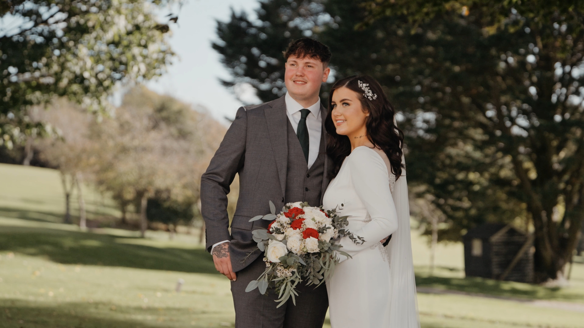 Bride and groom smiling together in a field during their couple portraits session — a relaxed and heartfelt moment to capture in your wedding video by a Somerset wedding videographer