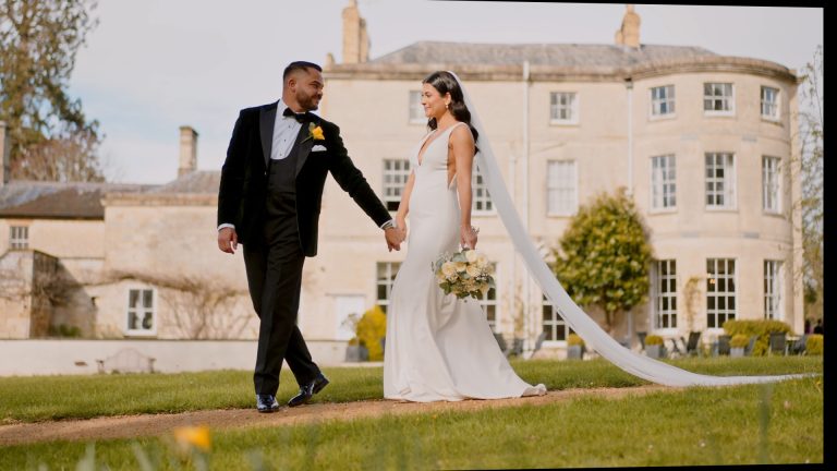 The bride and groom walk hand in hand through a beautifully manicured garden, a romantic moment captured in cinematic style by the Best Wedding Videographer in the South West.