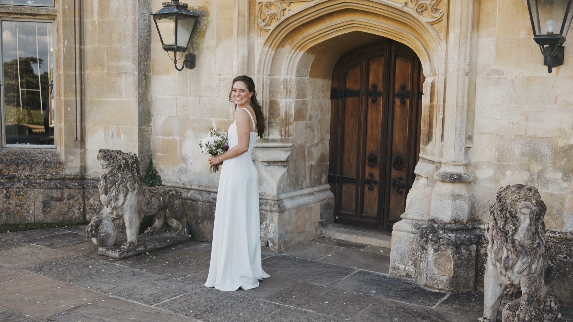 The bride poses for the camera with a radiant smile, exuding confidence and joy—an ideal example of how to look your best on camera during wedding photos.