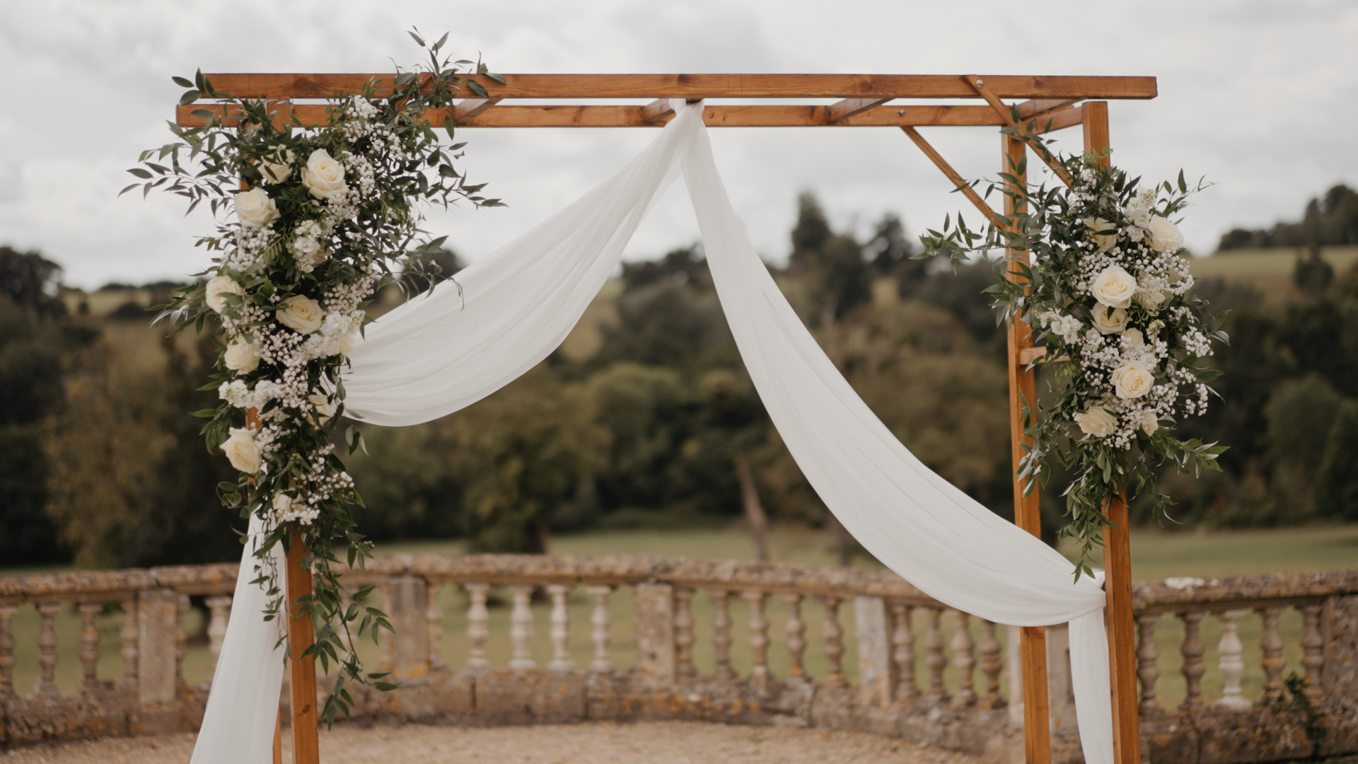 
White flowers beautifully arranged on a wedding arch, creating a fresh and elegant focal point that reflects the natural charm of a seasonal wedding ceremony.