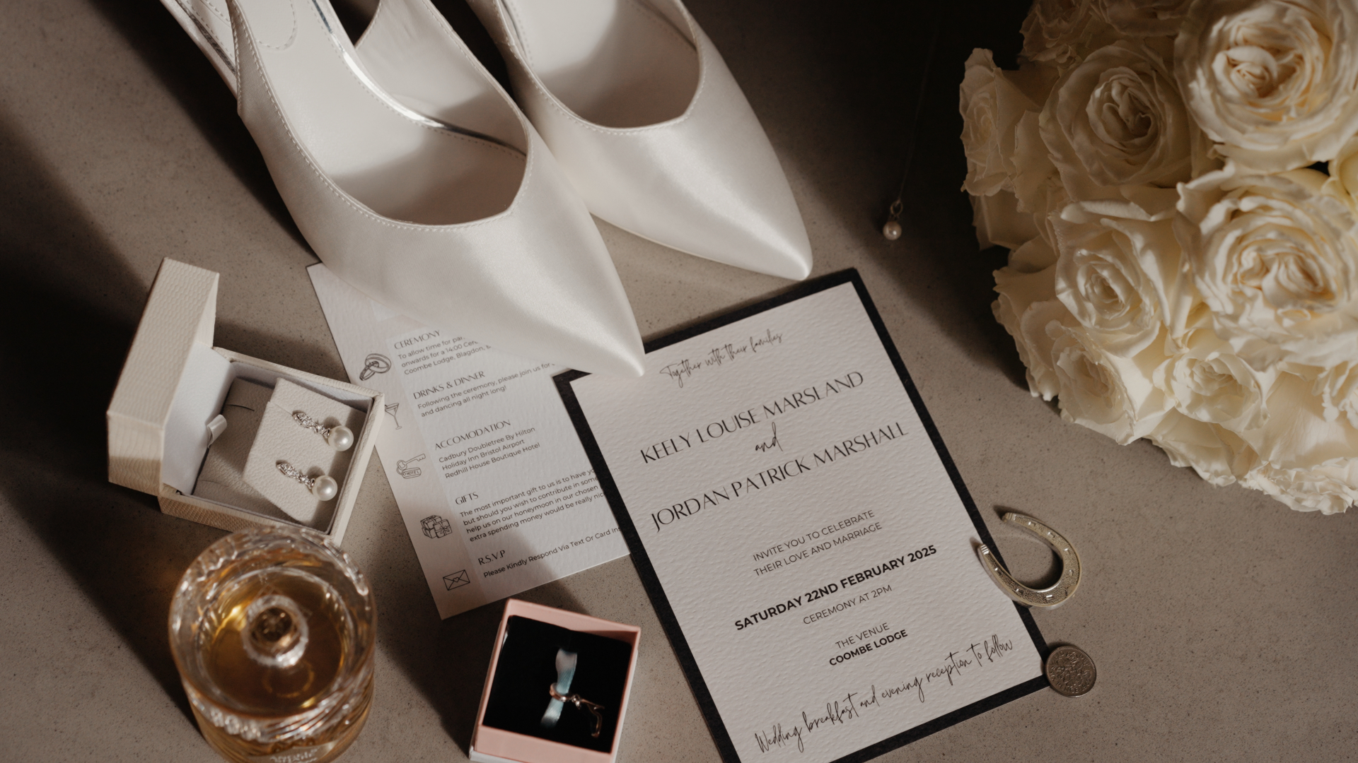 A timeless bridal flat lay of decorative wedding details featuring white heels, classic pearl earrings, wedding rings, and a floral invitation — the perfect combination of elegance and sentiment. 
