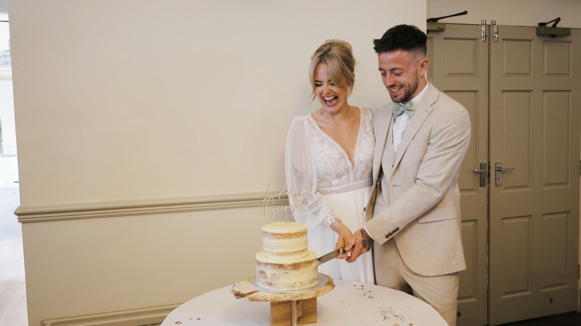 The bride and groom cutting their elegant white wedding cake together, surrounded by refined floral arrangements and table décor, showcasing charming and thoughtful decorative wedding details.