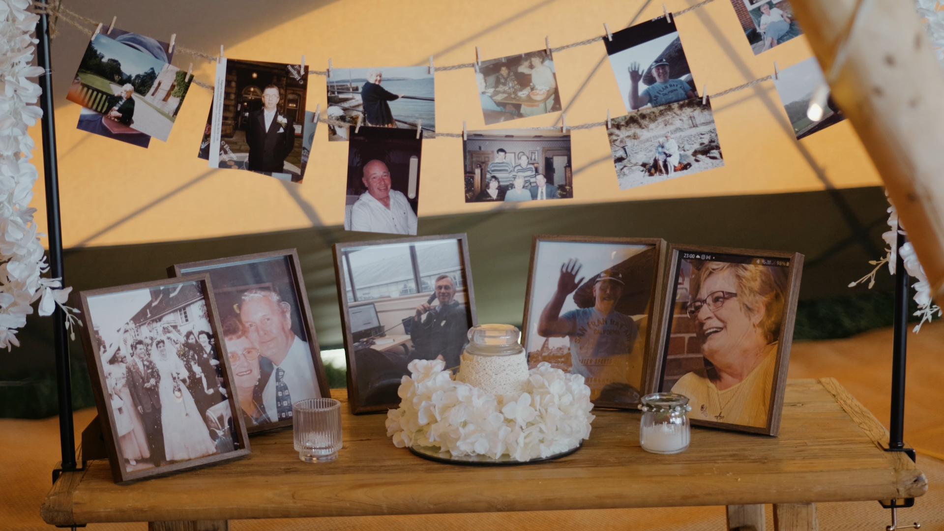 Personal images of loved ones displayed as keepsakes hanging in the wedding reception area, adding a heartfelt and intimate touch to the decorative wedding details.