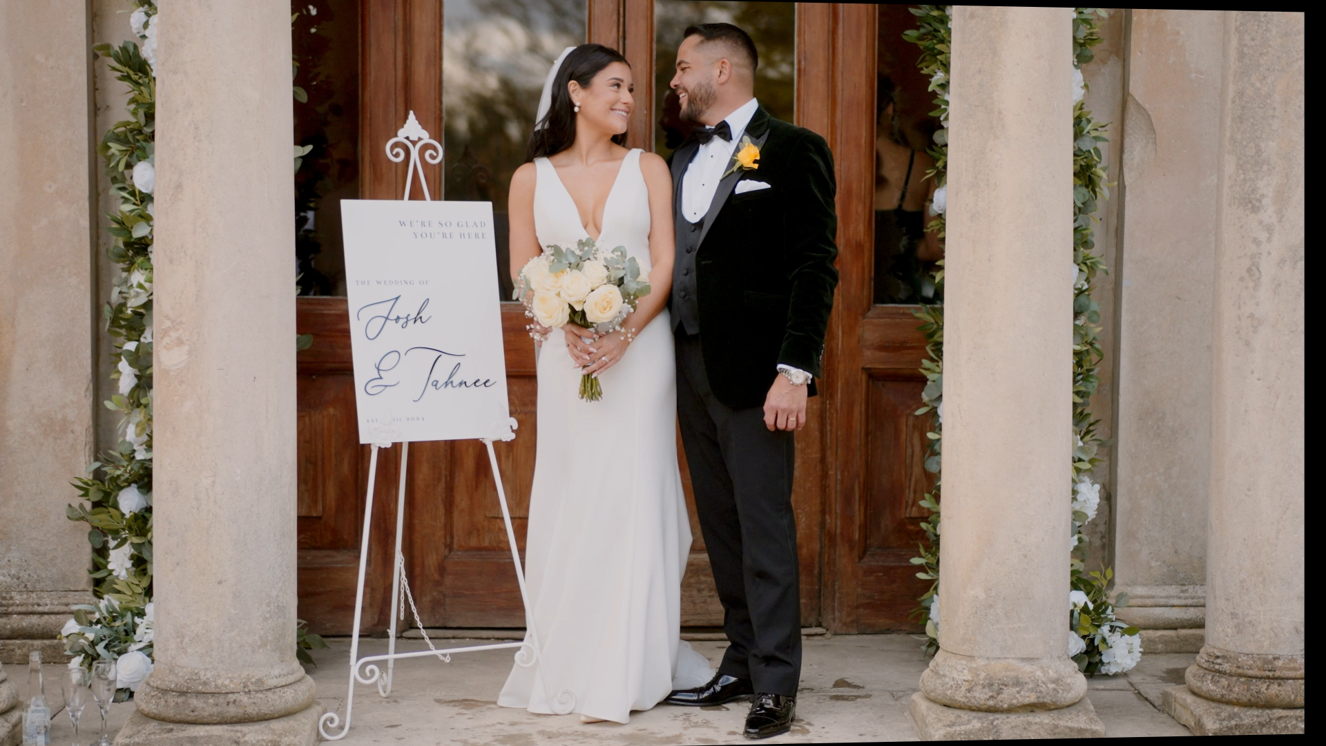 The bride and groom standing beside their elegant wedding welcome signage board, showcasing thoughtful and stylish decorative wedding details that set the tone for their celebration.