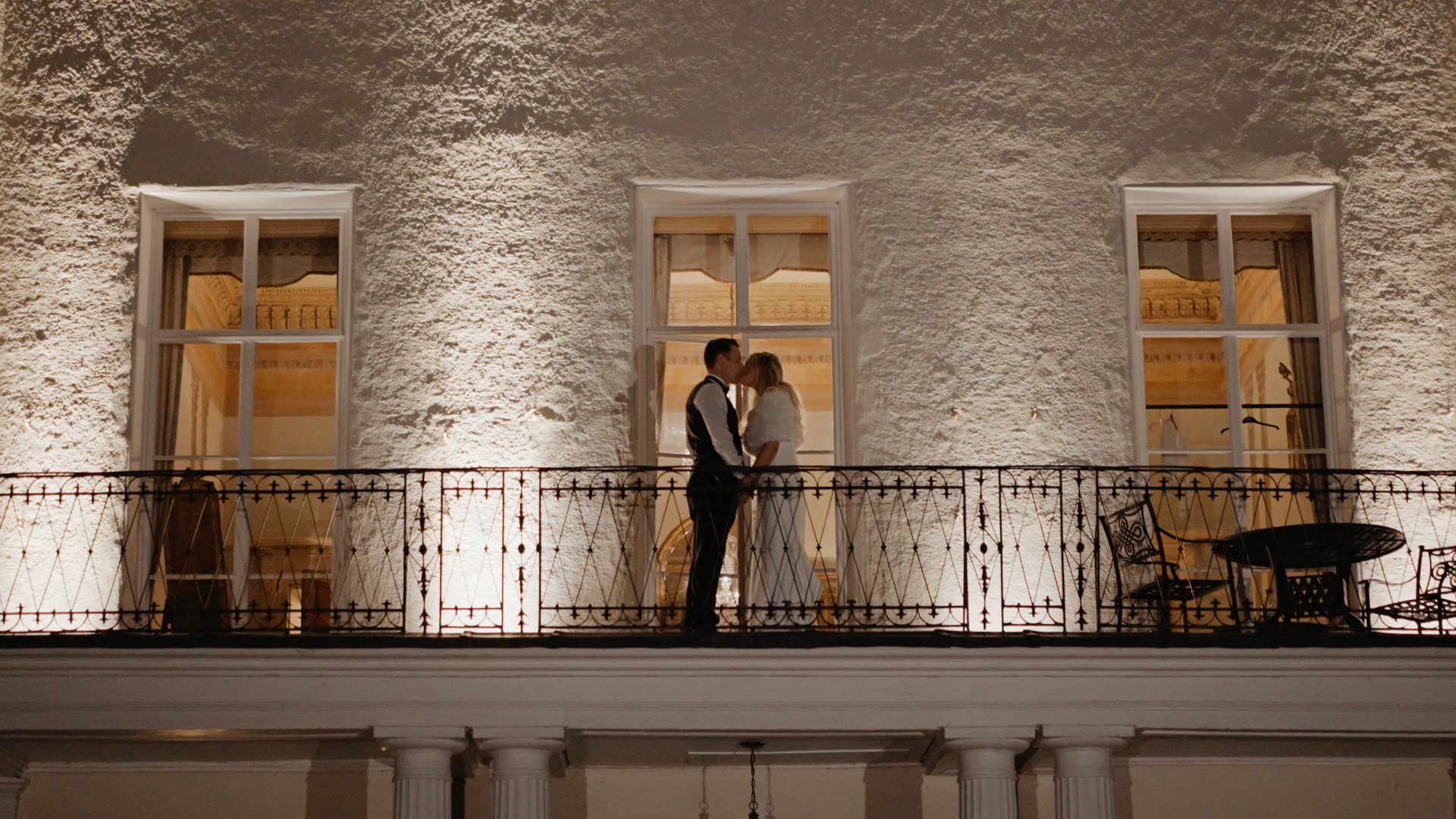 Bride and groom sharing a kiss on their wedding day, a special moment featured in their wedding video package.