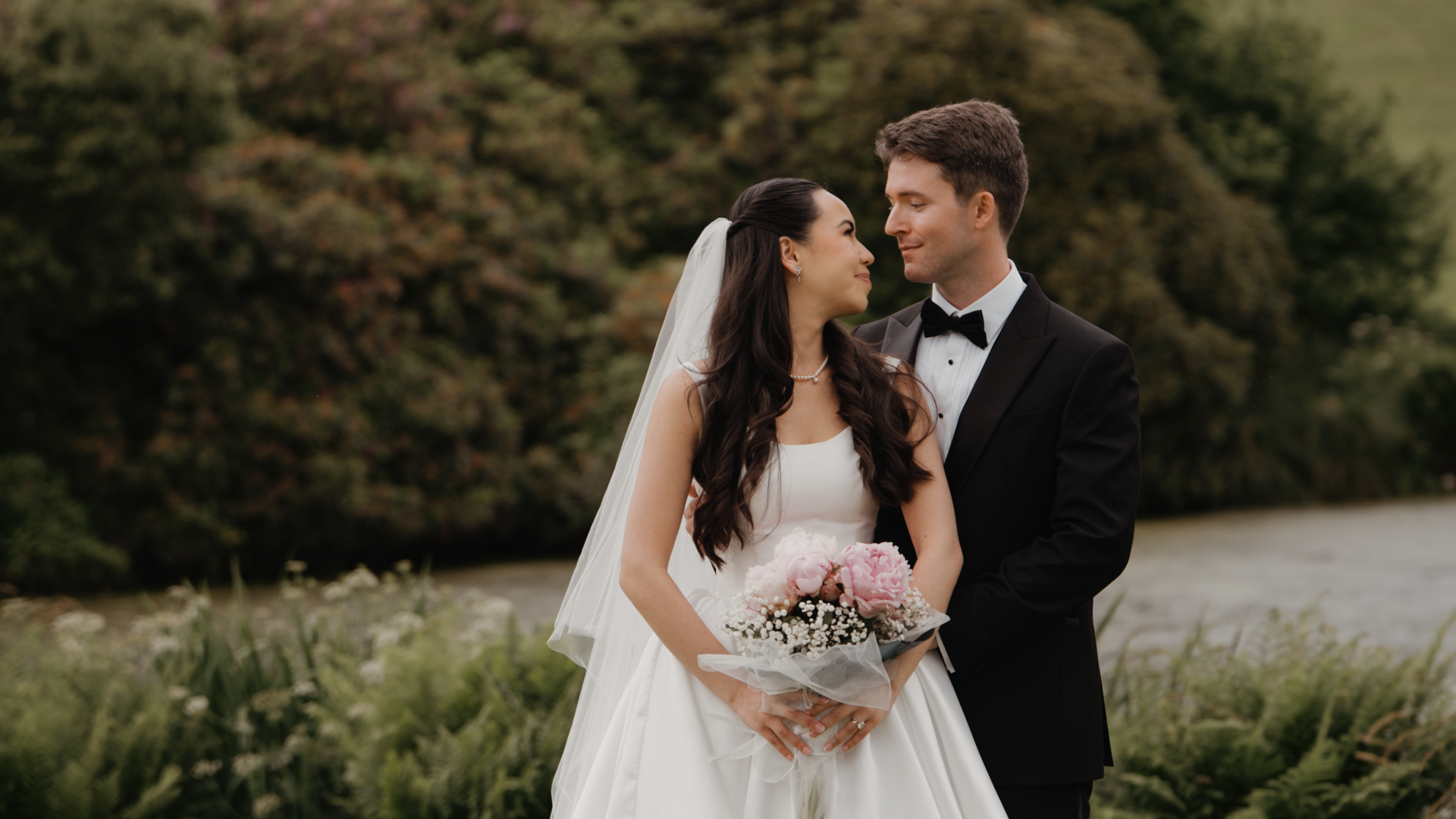 Newlyweds share a tender gaze with the picturesque Bovey Castle estate in the background.