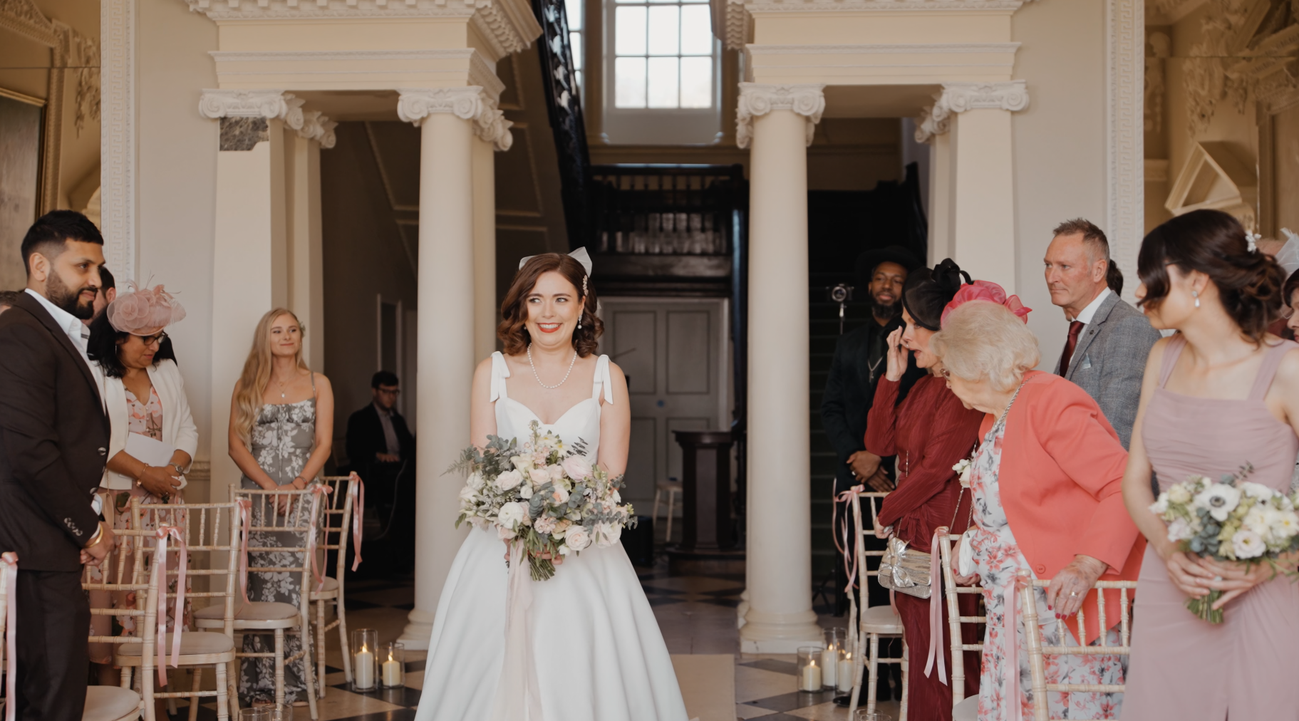 Radiant bride smiles while walking down the aisle during a wedding at Crowcombe Court.