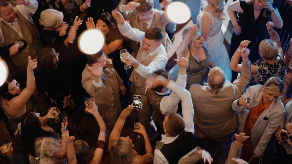 Top-down view of an intimate wedding reception at Clevedon Hall, with guests dancing, laughing, and celebrating late into the night on the joyful dancefloor.