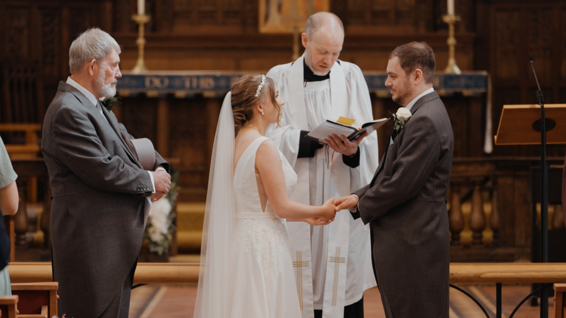 Bride and groom exchanging vows during their wedding ceremony inside Huntsham Court, beautifully captured by the videographer.