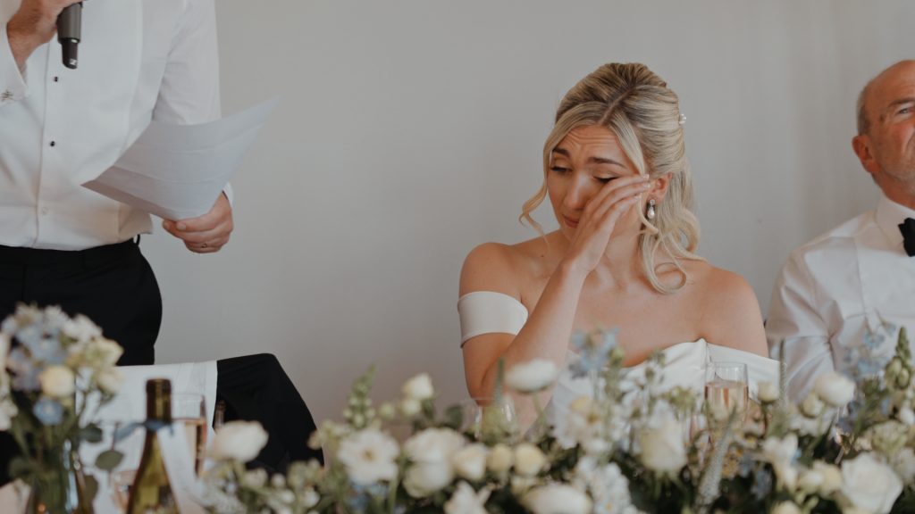 Close-up of the bride moved to tears by a deeply personal and emotional wedding speech.