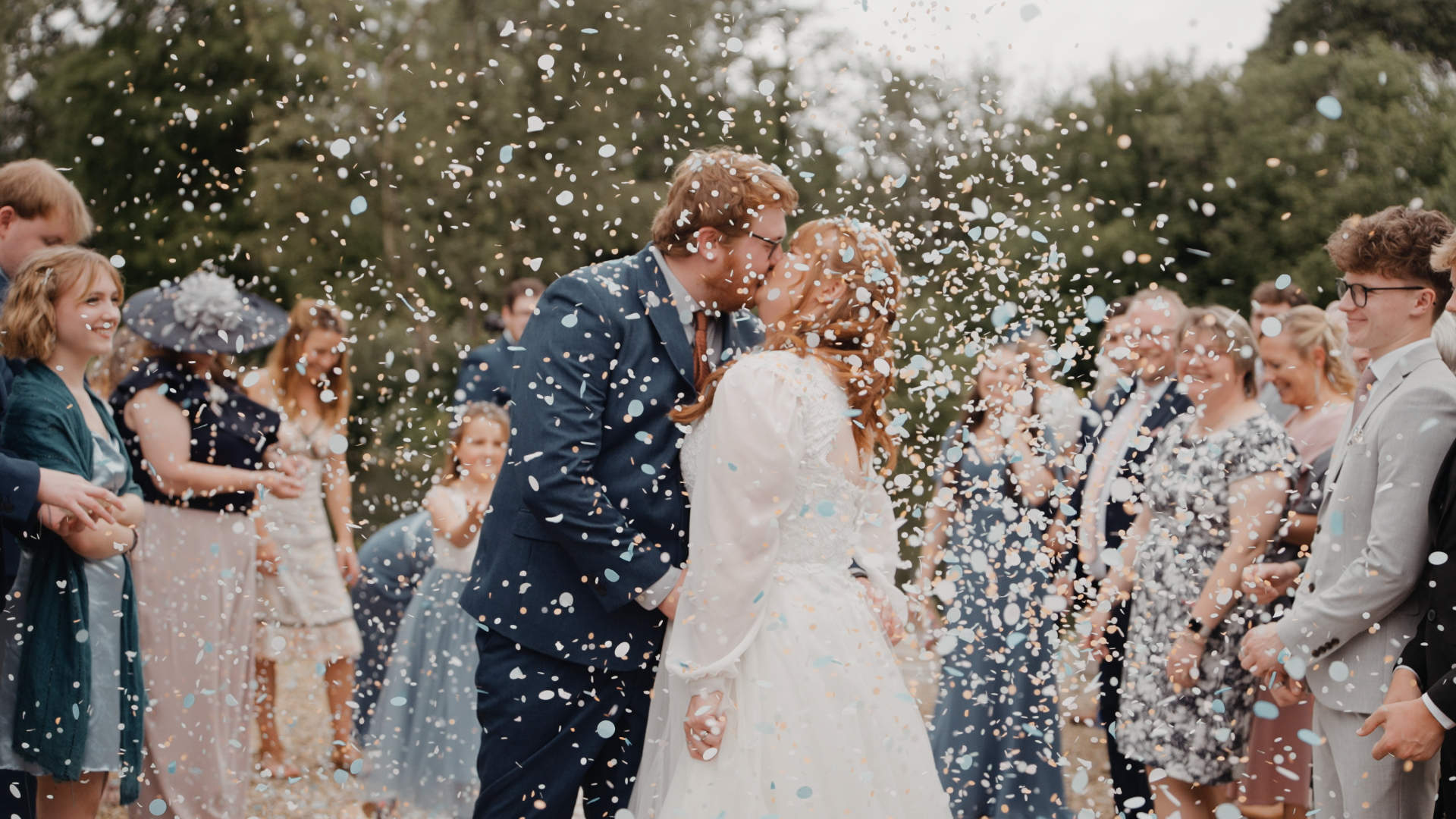 A romantic kiss under a shower of confetti, a perfect moment for the couple’s wedding highlight reel.