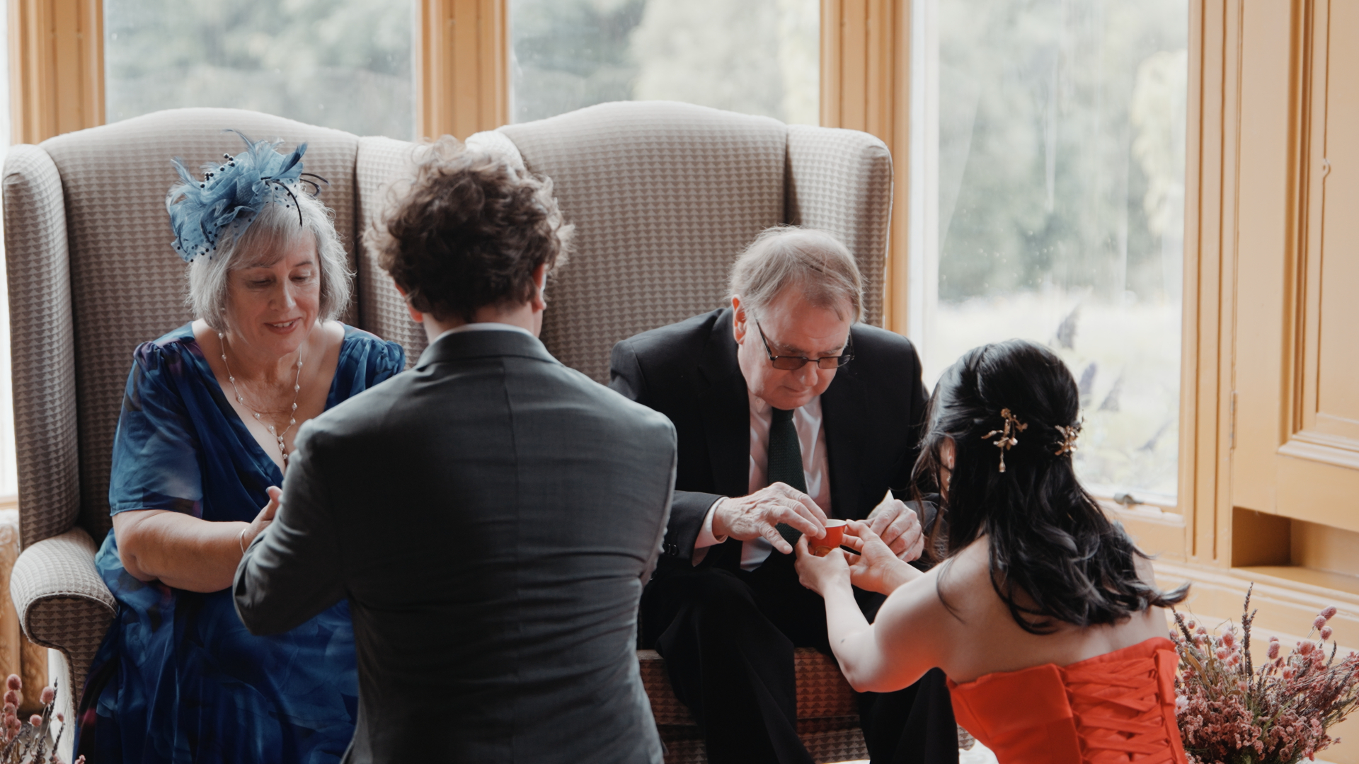 Bride and groom sharing a traditional tea ceremony with family during a Somerset wedding celebration.