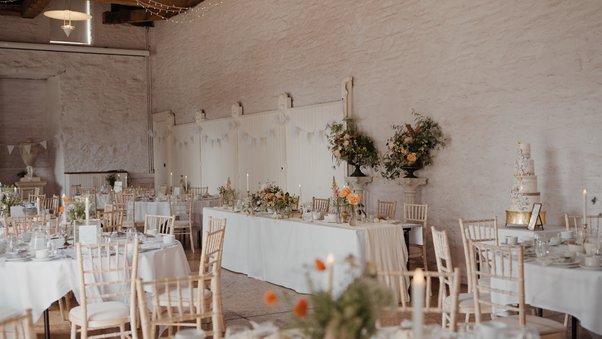A vibrant spring wedding table setting at Hestercombe House & Gardens, featuring a place card with a delicate Scottish Deerhound illustration, harmonizing with the elegant floral arrangements and soft pastel palette.