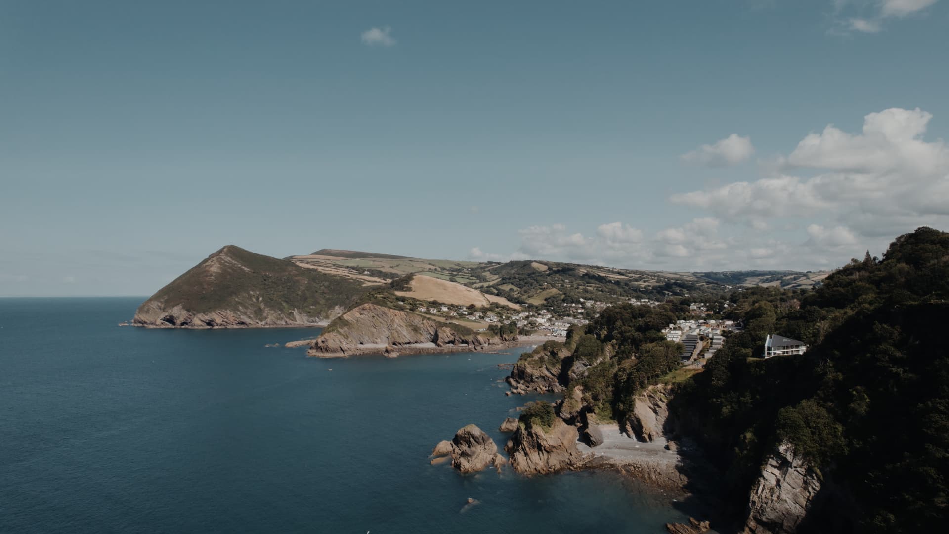 Aerial view of Sandy Cove Hotel perched on Devon’s dramatic coastline, showcasing the perfect seaside wedding venue.
