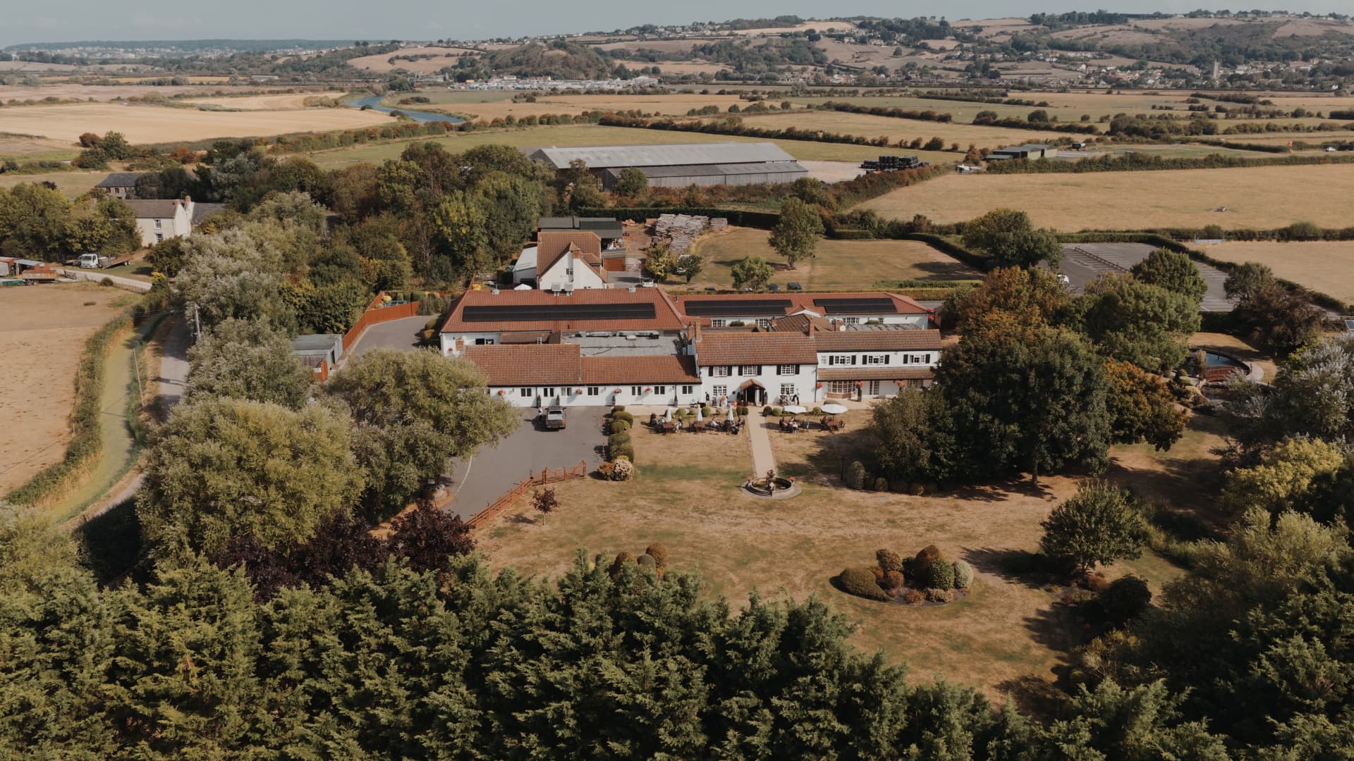 A cinematic aerial shot of Batch Country House in Somerset, showing the full estate and its beautiful rustic grounds.