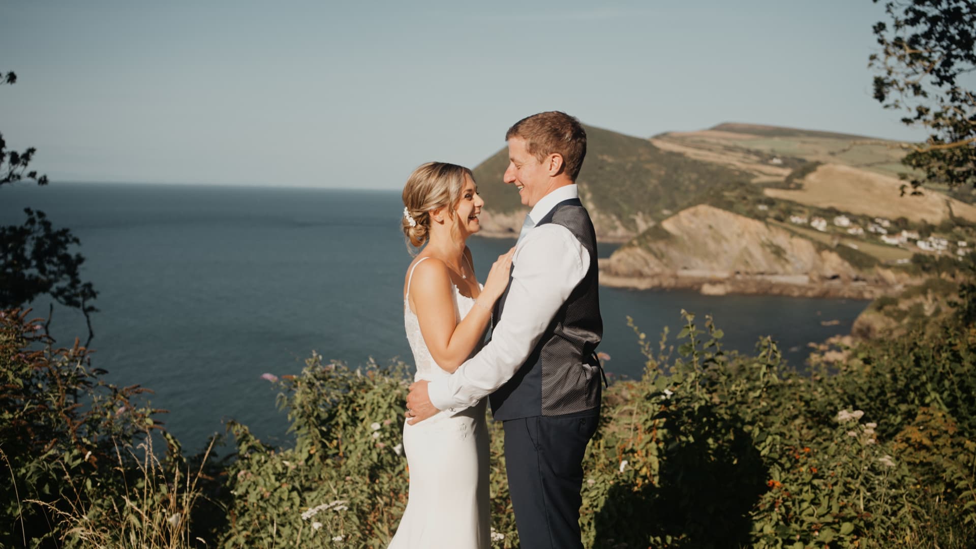 Couple sharing a romantic moment overlooking the ocean at Sandy Cove Hotel in Devon, captured beautifully at sunset.