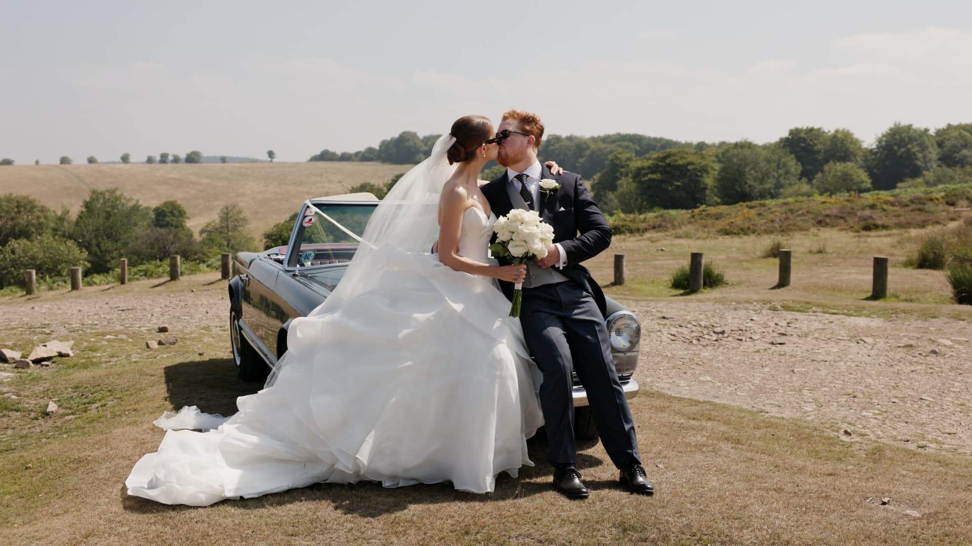 Bride and groom posing with a vintage Mercedes outside Crowcombe Court, blending timeless elegance with countryside charm.