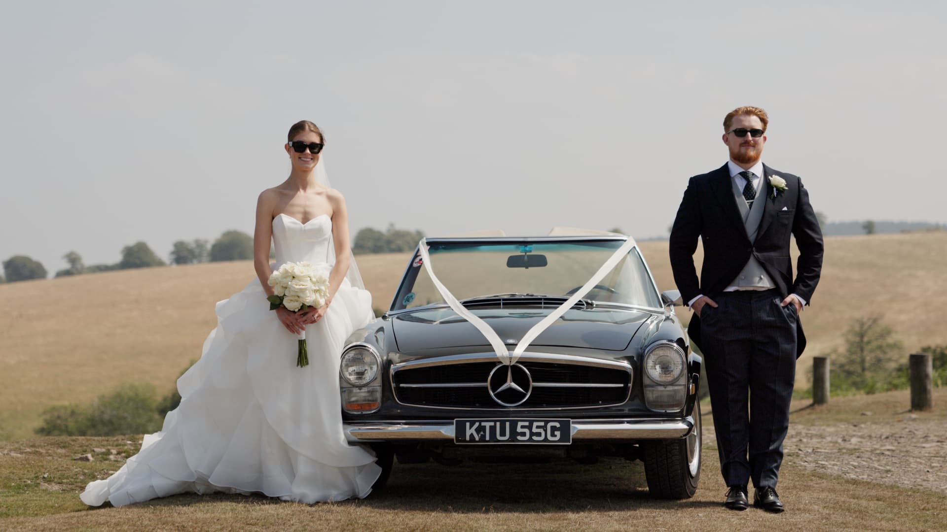Bride and groom standing beside a classic Mercedes outside Crowcombe Court, showcasing their elegant wedding style.