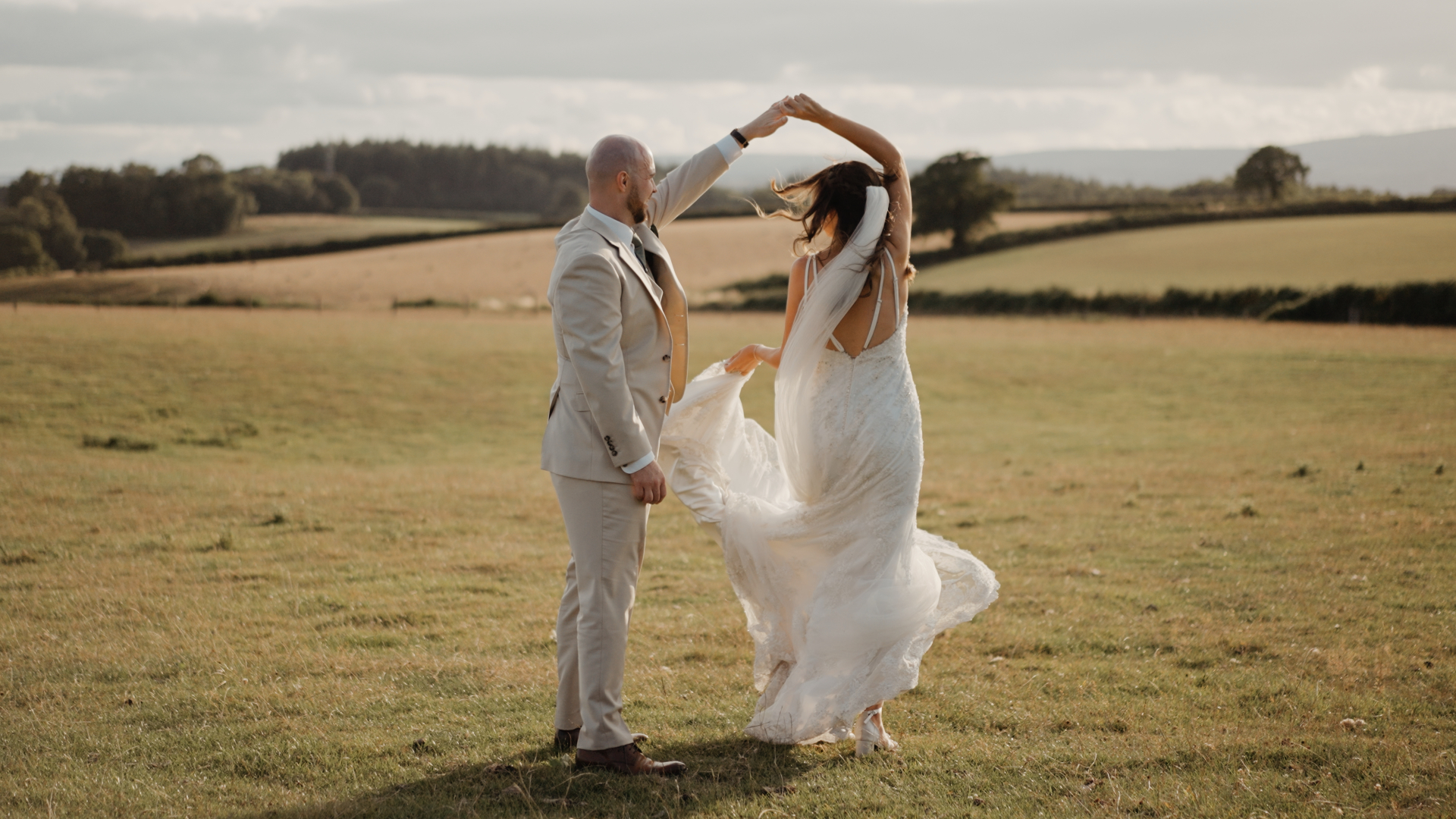 Bride spinning in open fields at Humber Barn during golden hour, a romantic moment from a cinematic wedding film