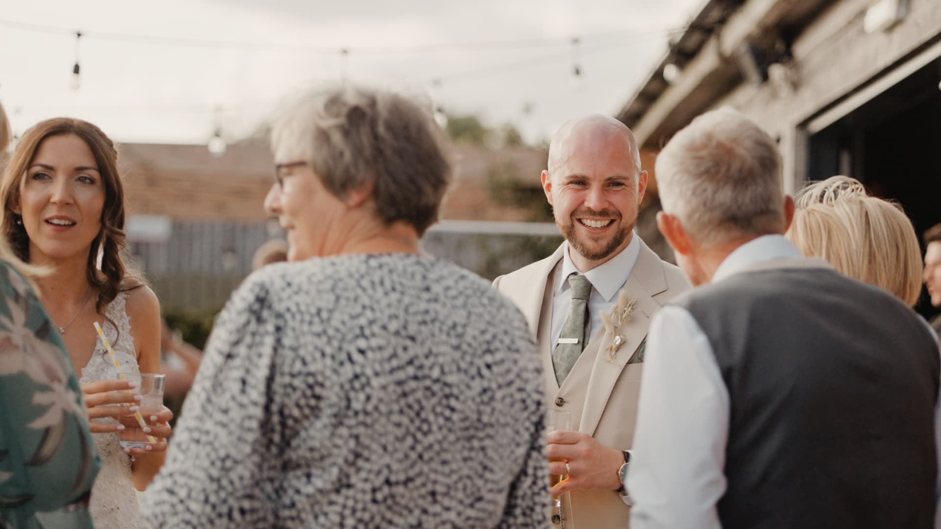 Bride and groom chatting with guests during their Humber Barn wedding reception, sharing laughter and relaxed post-ceremony drinks.