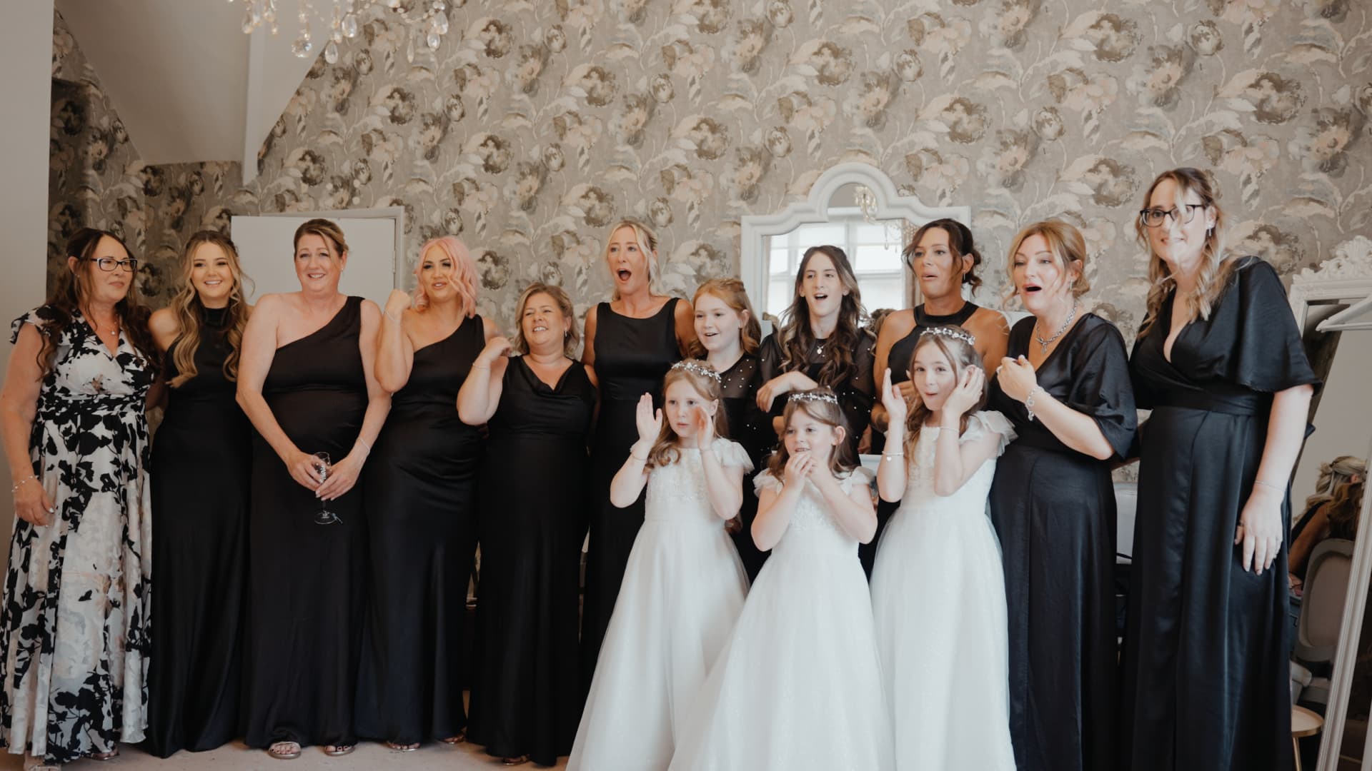 Bridesmaids and flower girls react with excitement as they see the bride ready for her wedding day in Somerset.