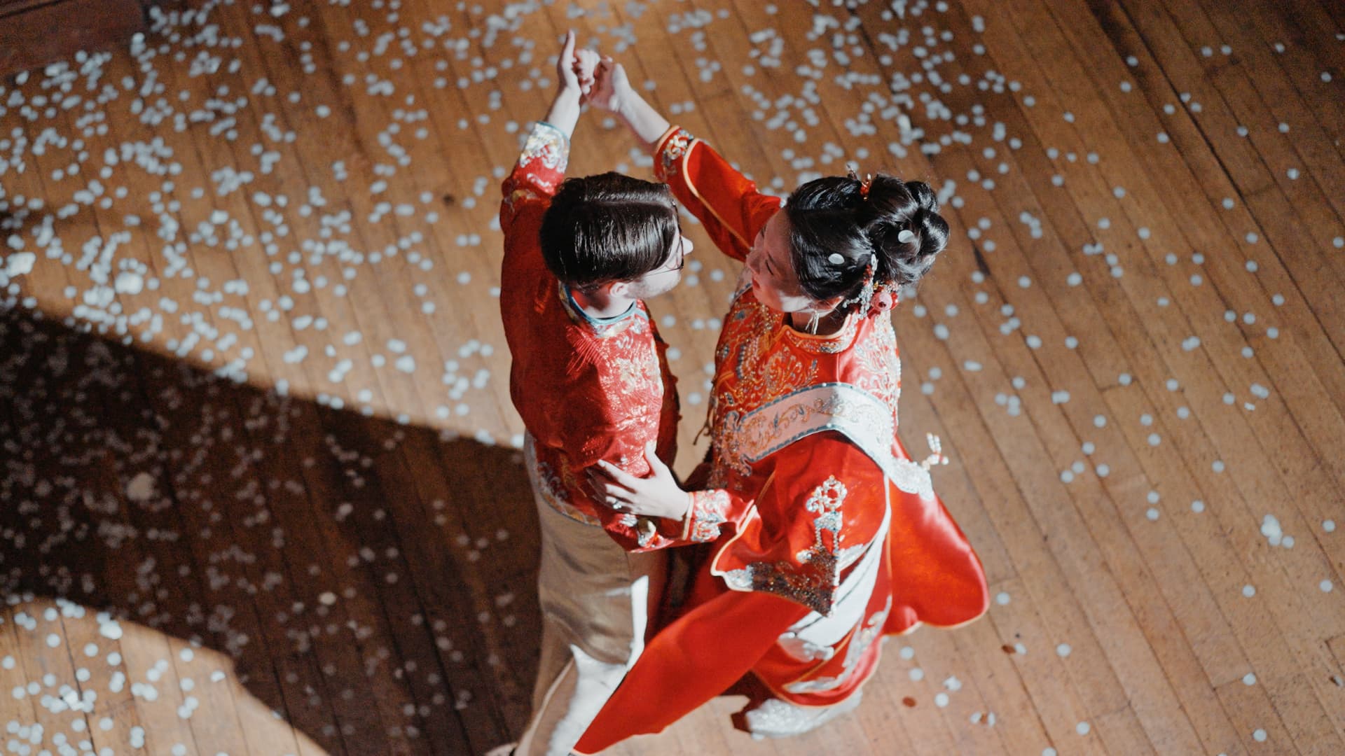 Couple in traditional attire dancing on a wooden floor at Holmewood Hall, captured in a documentary wedding film style