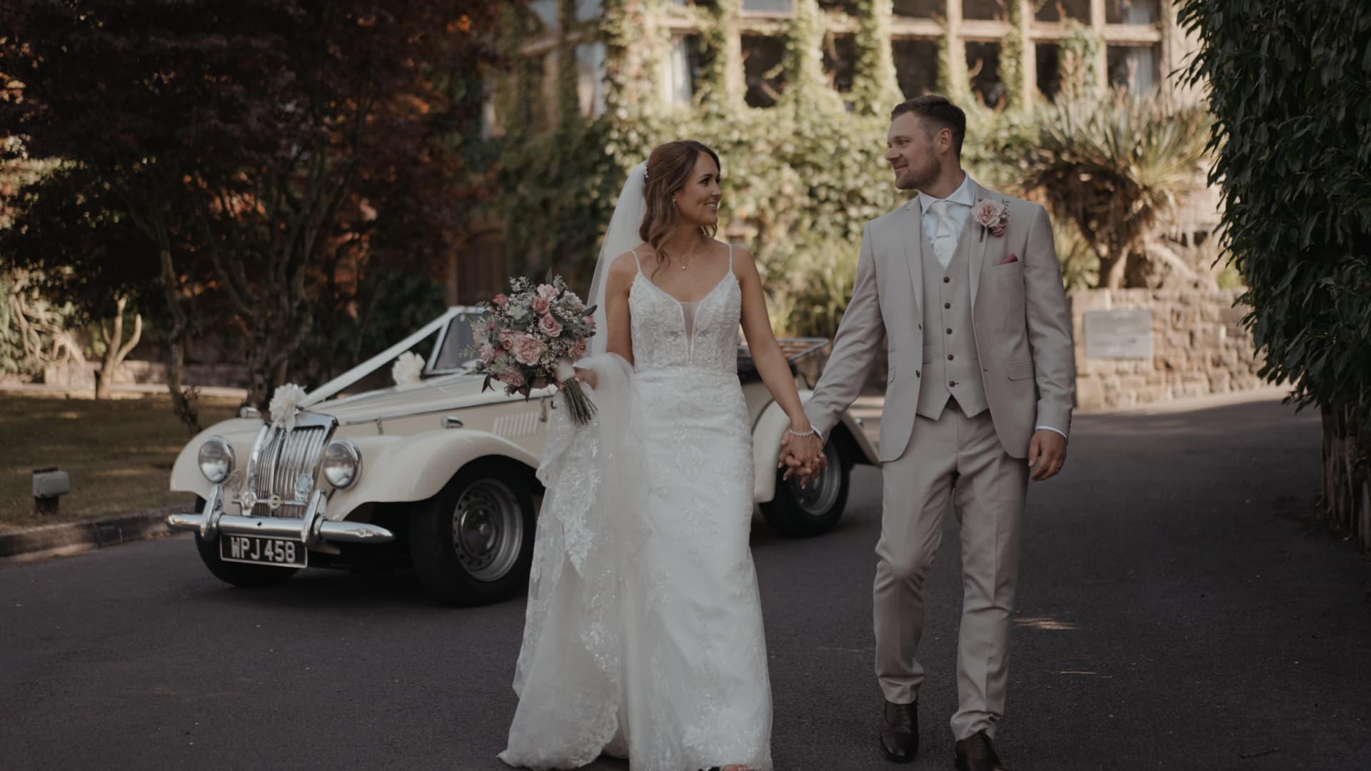 Couple sharing a romantic walk with their vintage car during a Cadbury House Wedding.