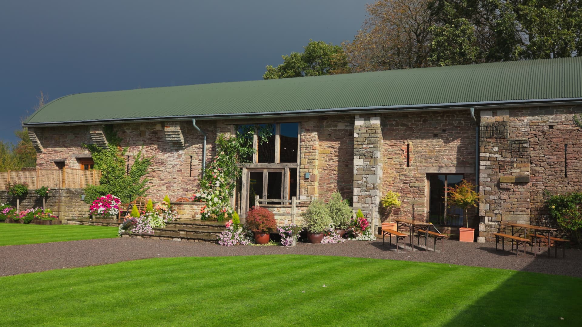 Stone barn exterior at a Naas Court Farm Wedding in the Forest of Dean, showcasing the rustic wedding venue and landscaped gardens.