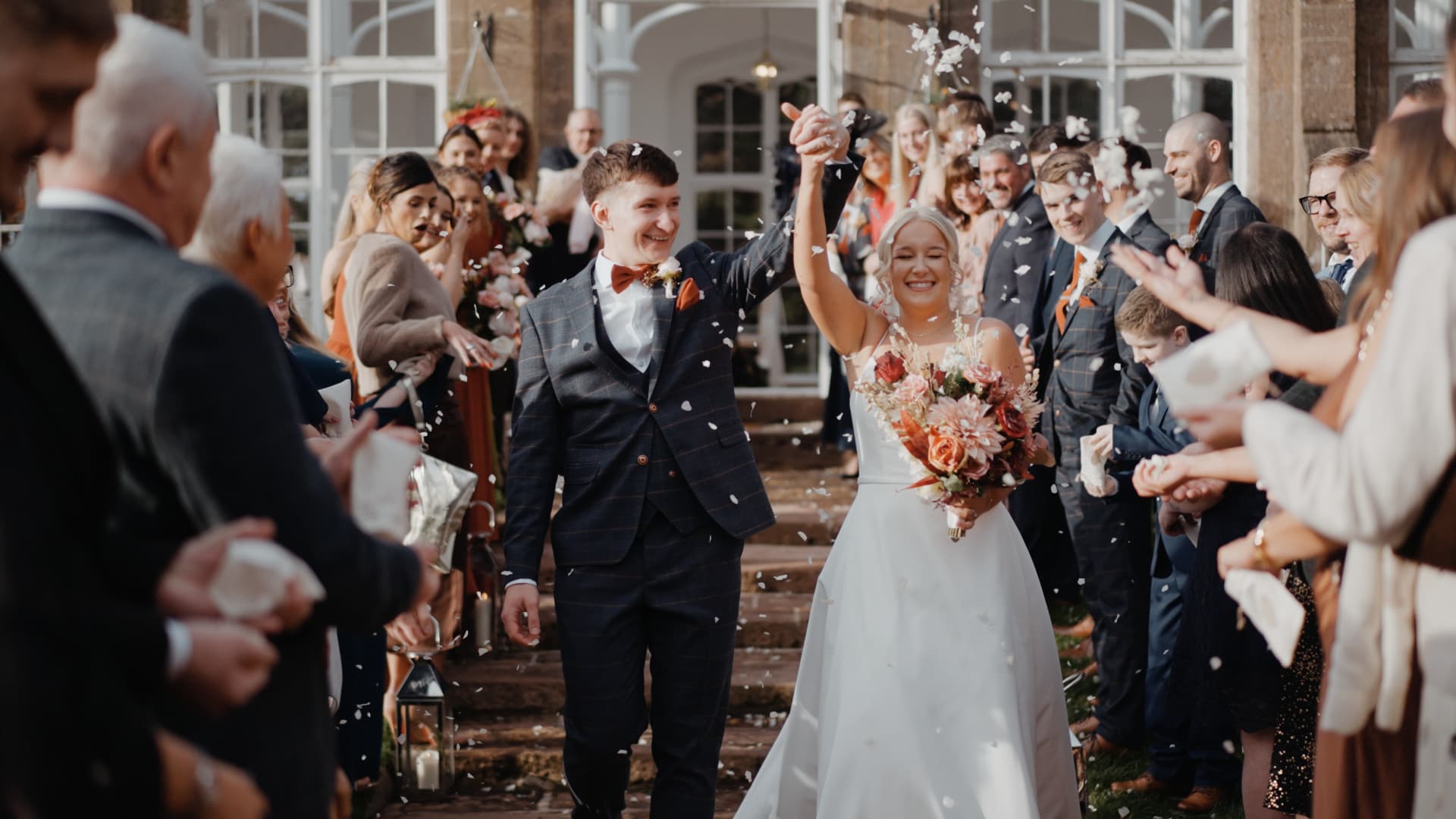 Joyful confetti exit as guests celebrate the newlyweds in a cinematic wedding film