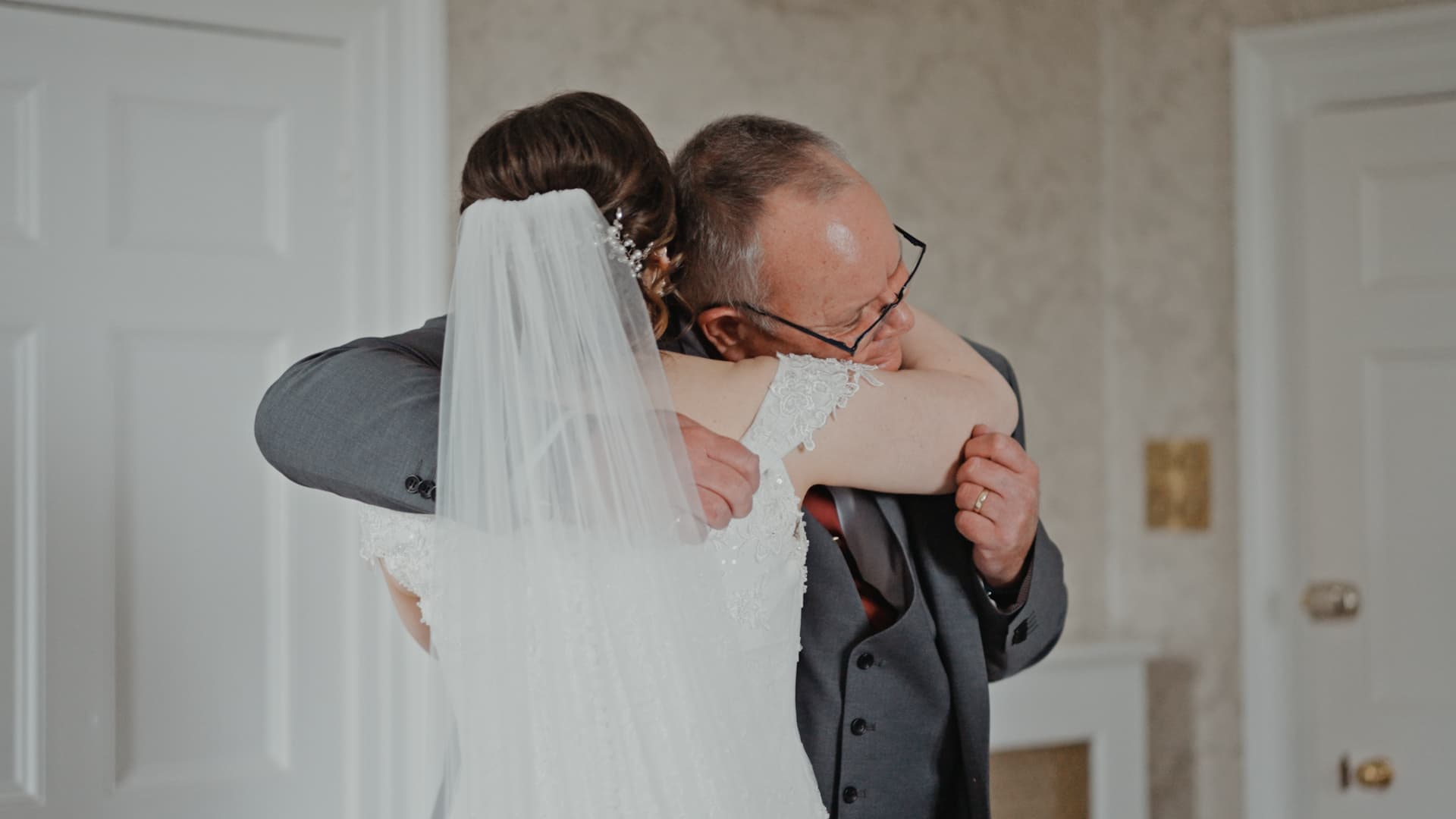 Emotional moment between bride and her father during morning preparations, documented by a Wedding Videographer