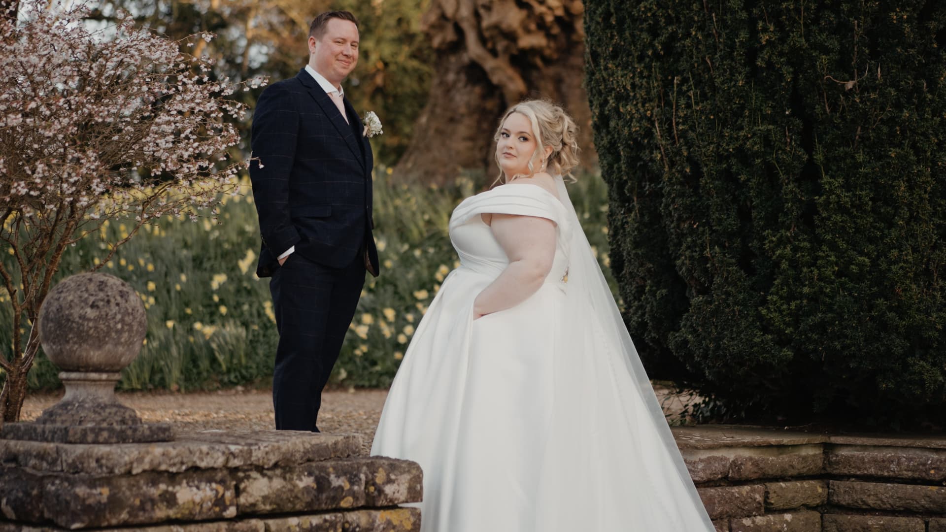 Elegant bride and groom posing together in the gardens at Coombe Lodge Blagdon during their Somerset wedding.