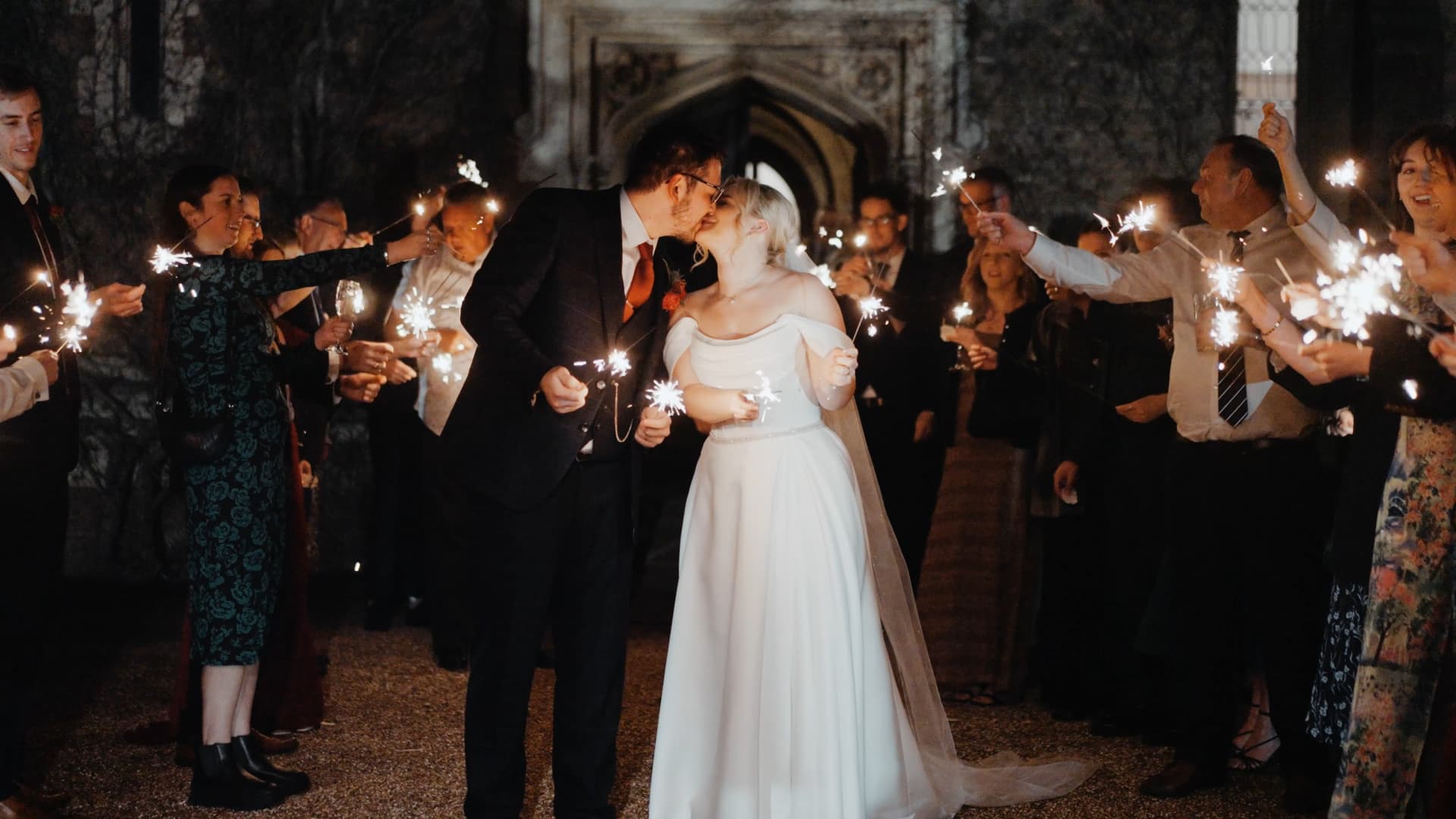 Romantic sparkler exit at St Audries Park wedding filmed by a Somerset wedding videographer with guests surrounding the couple at night