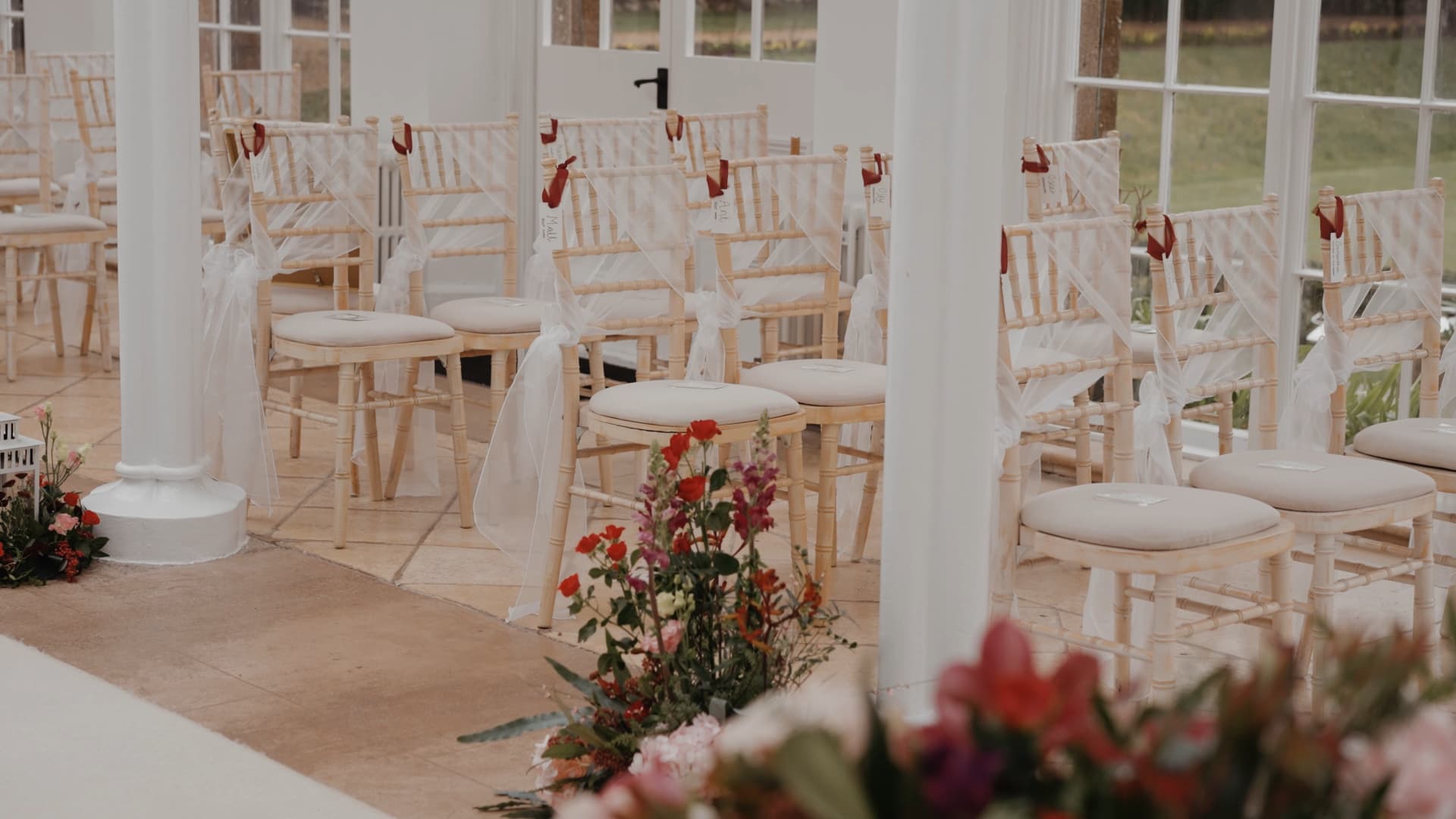 Elegant orangery ceremony setup at St Audries Park wedding with chiavari chairs, soft draping and florals captured in a Somerset wedding film