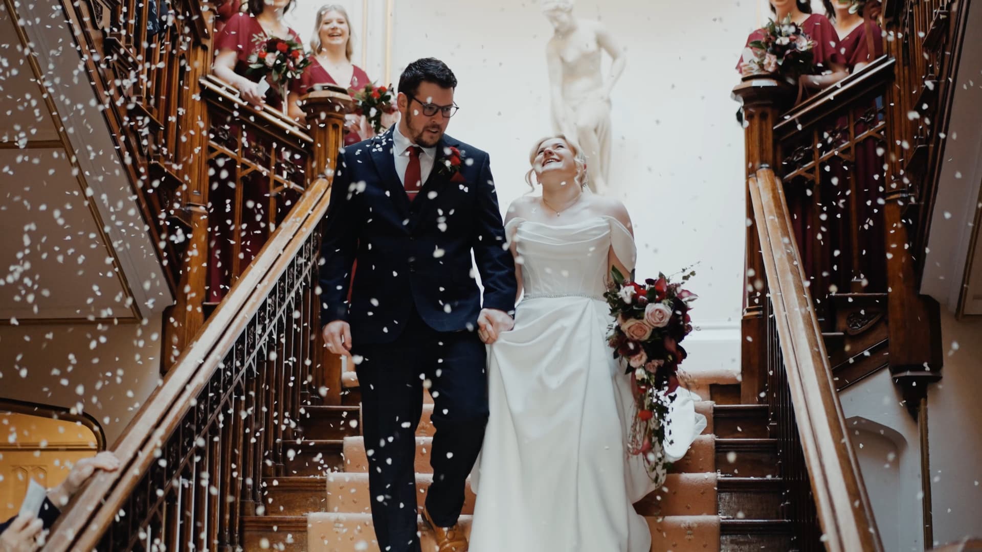 Confetti moment on staircase at St Audries Park wedding captured in a luxury wedding film with joyful movement and soft light