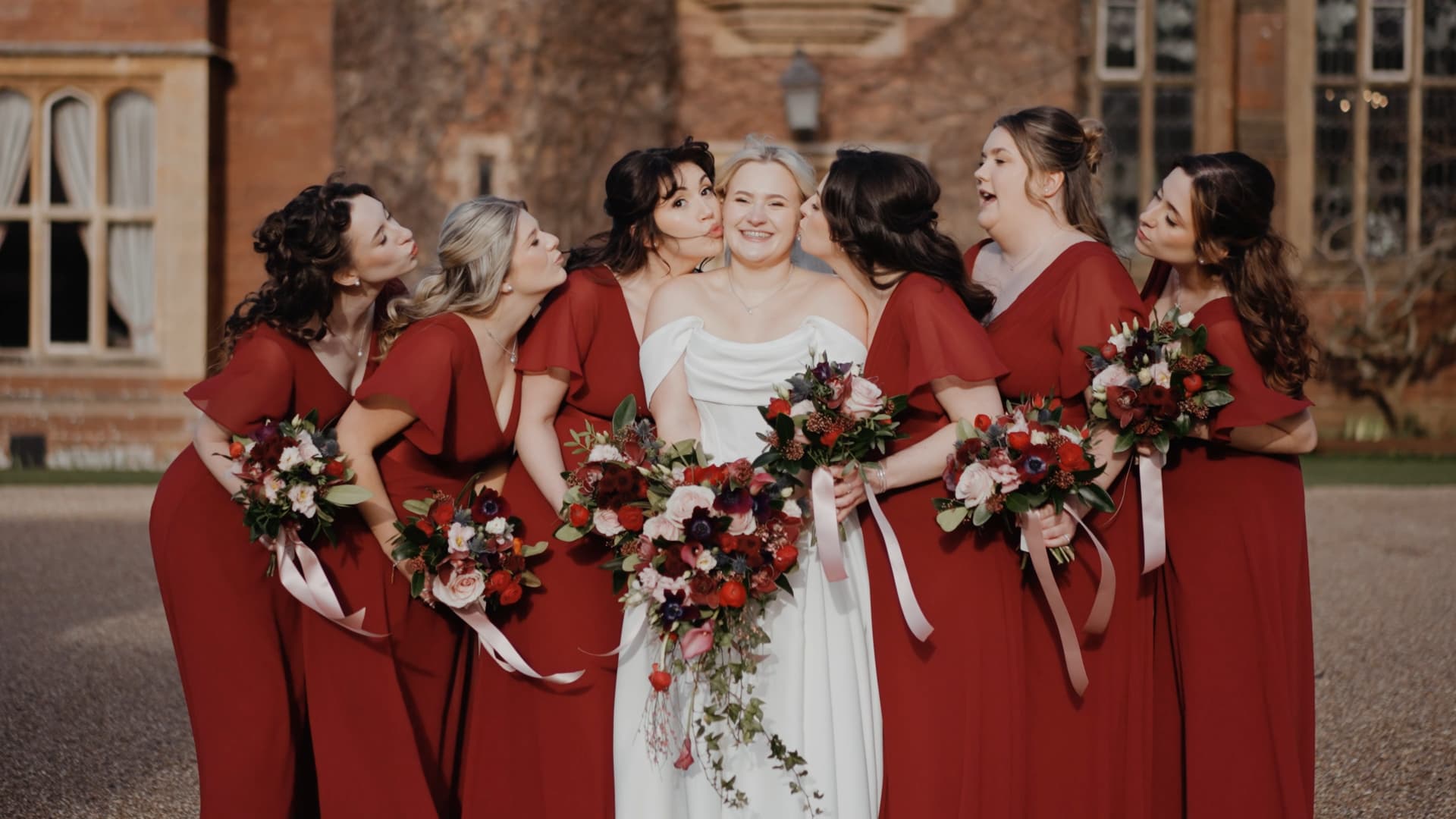 Bridal party portrait at St Audries Park wedding with bridesmaids in burgundy dresses captured in elegant wedding videography style