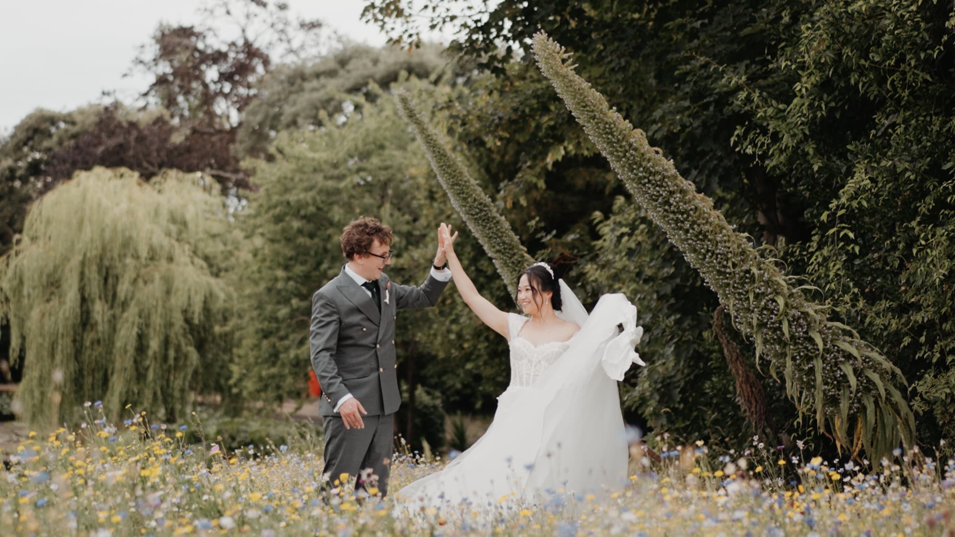 Bride and groom celebrating in the gardens at Clevedon Hall, Somerset, captured in a luxury documentary wedding film by a Somerset wedding videographer
