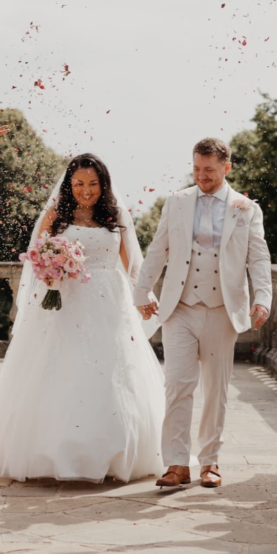 Confetti wedding exit at Cliveden House, Berkshire with guests celebrating, filmed by a UK wedding videographer specialising in luxury documentary wedding film