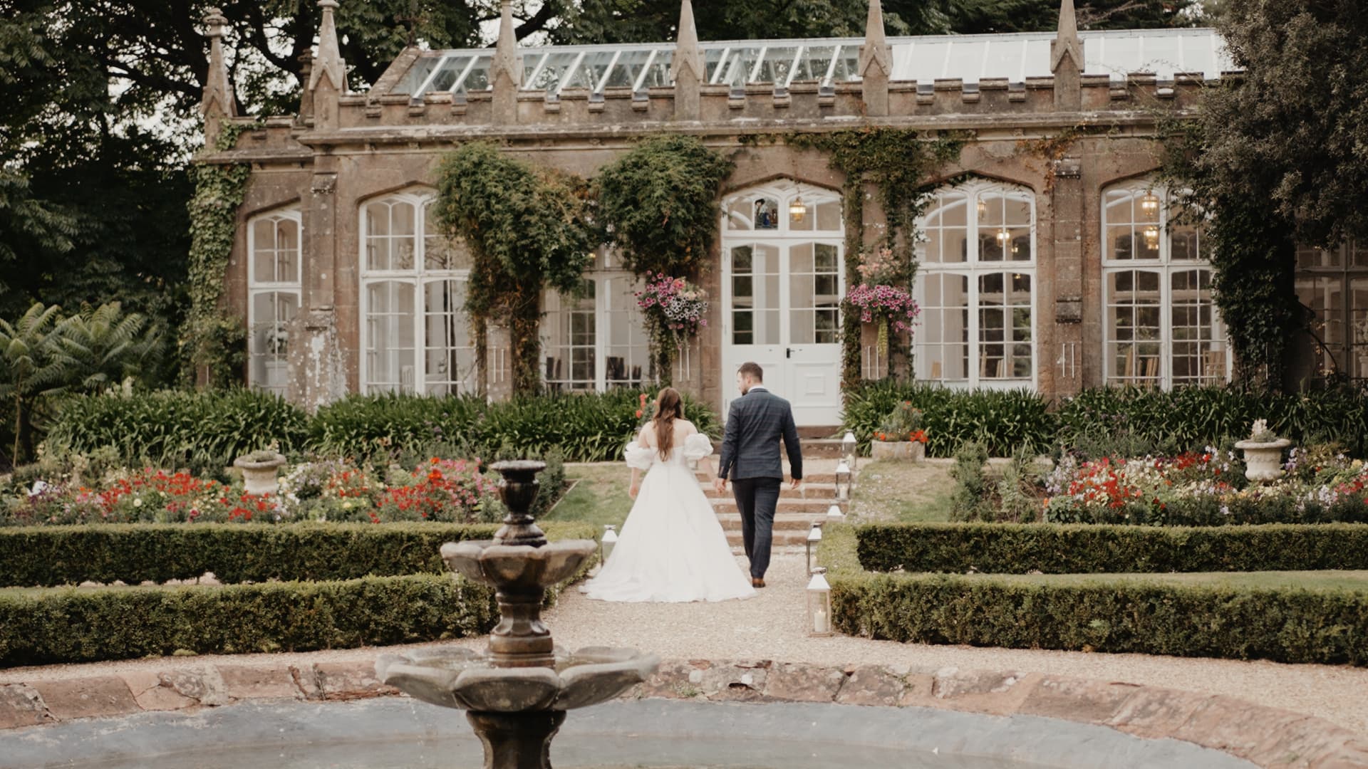 Bride and groom walking through the gardens at St Audries Park in Somerset, filmed in a natural cinematic wedding film style by a Somerset based wedding videographer.