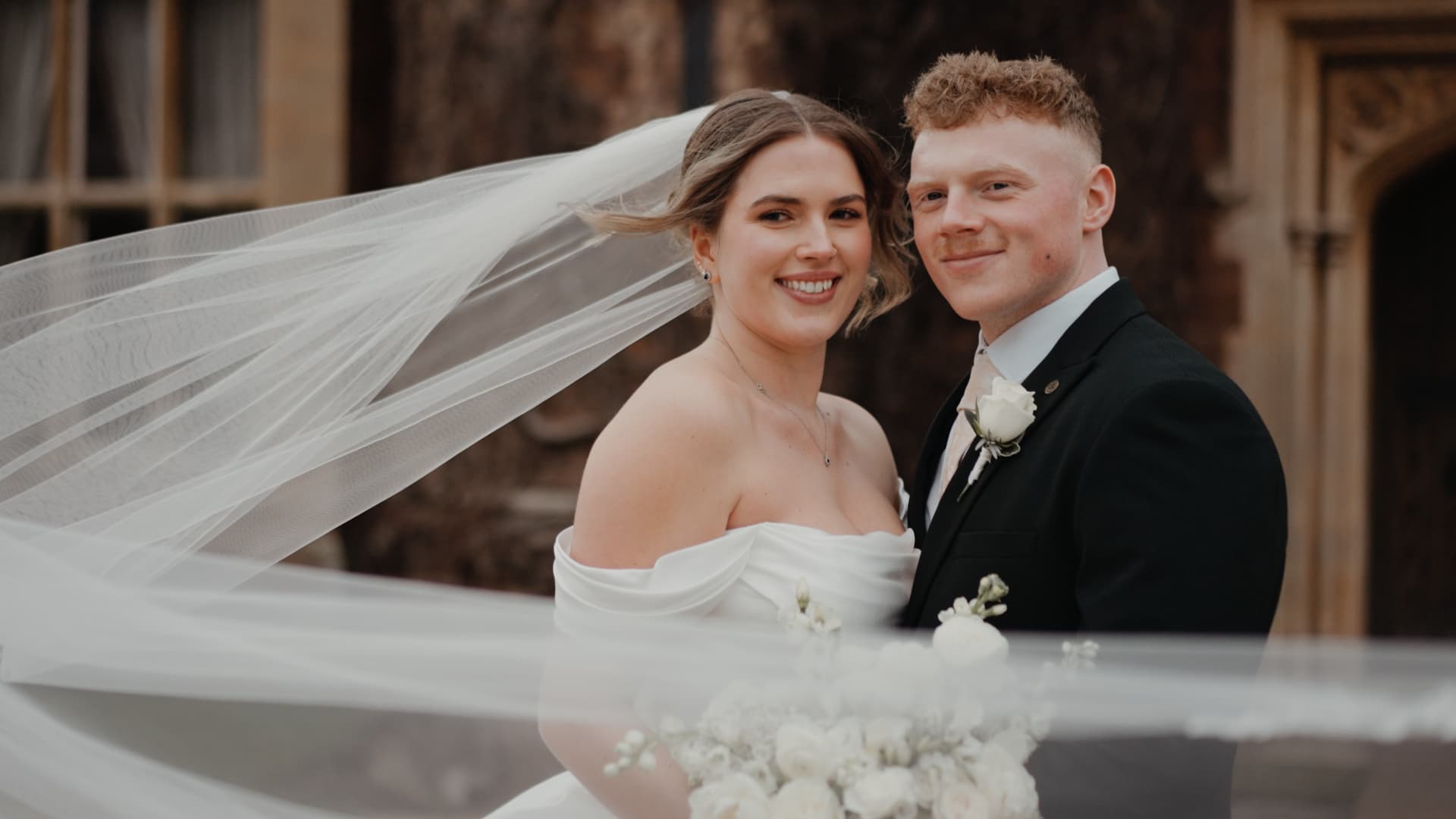 Bride and groom smiling together with flowing veil at St Audries Park in Somerset, captured in a cinematic luxury documentary wedding film by a South West wedding videographer