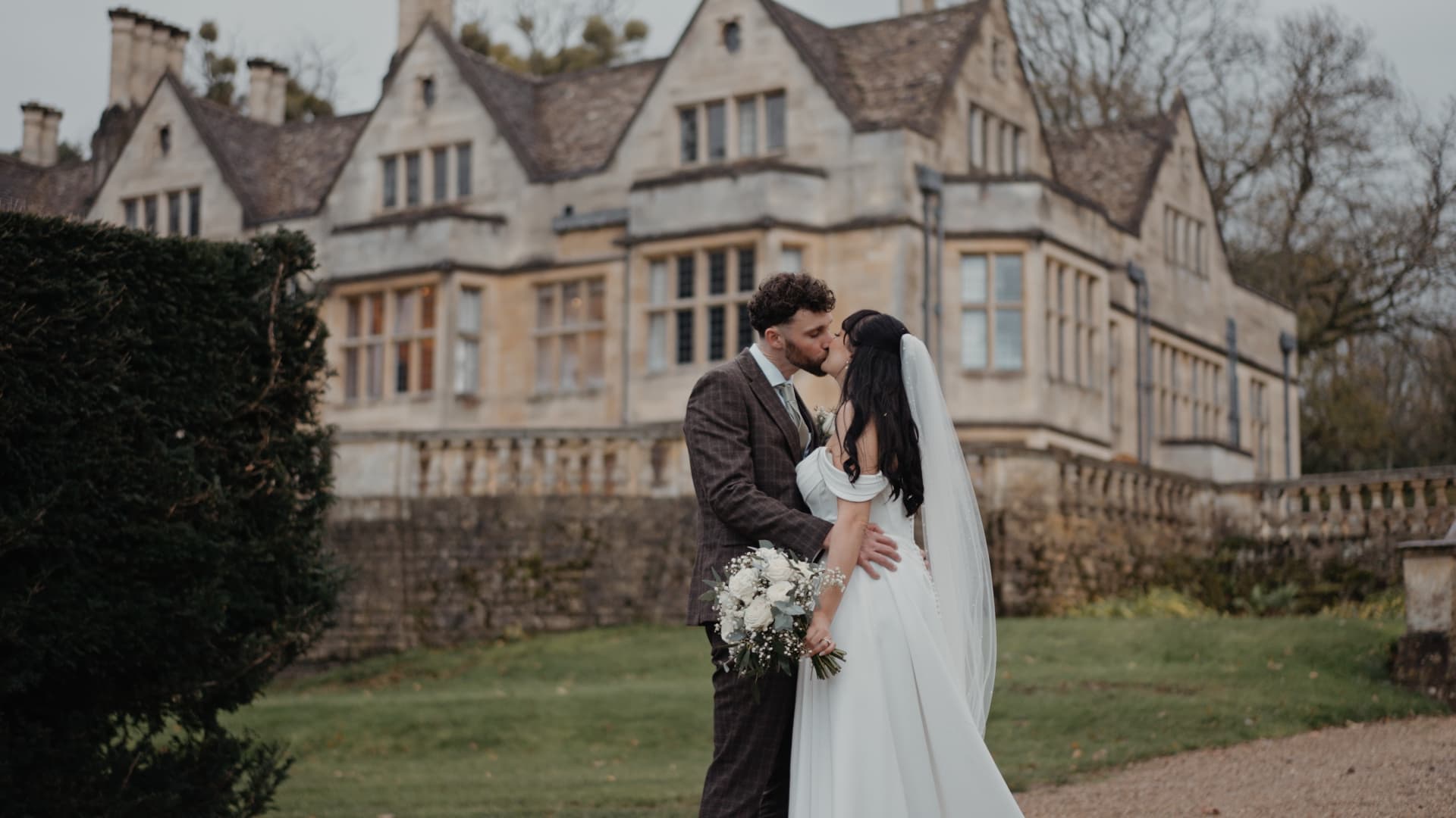 Bride and groom sharing a kiss at Coombe Lodge in Somerset, captured by a Somerset based wedding videographer in a natural, cinematic wedding film style with luxury documentary wedding film feel.