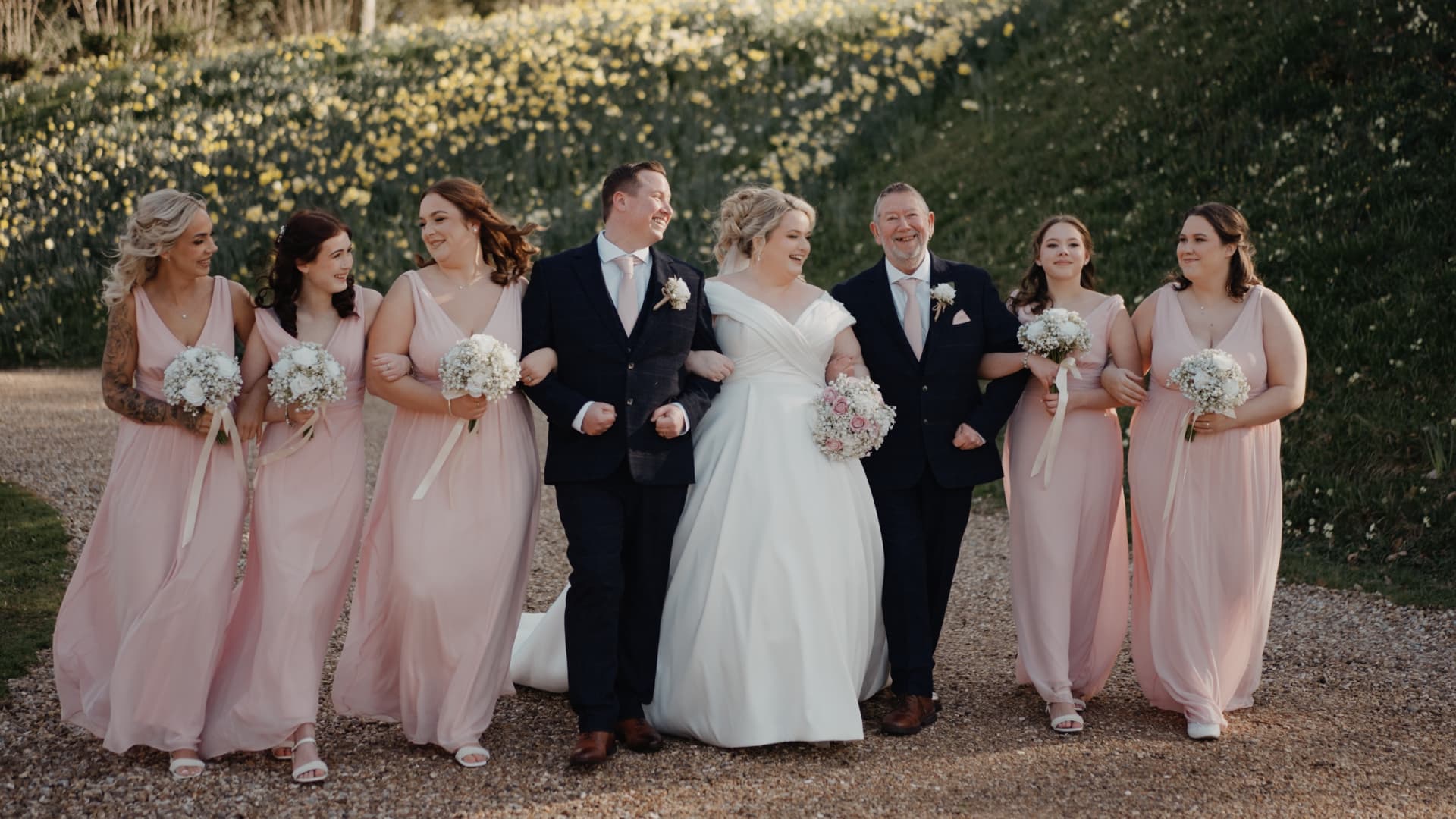Bride and groom surrounded by bridesmaids and groomsmen in the beautiful Coombe Lodge Blagdon grounds, celebrating together during their Somerset wedding.