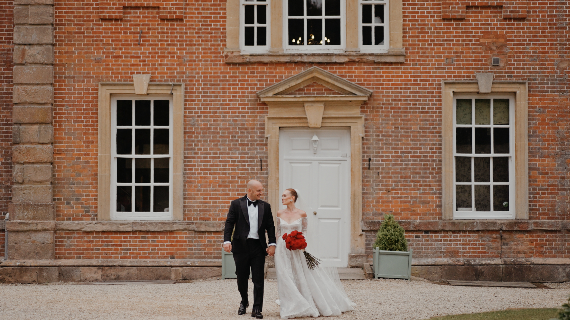 Bride and groom walking hand in hand outside Crowcombe Court, captured in a timeless wedding videography.