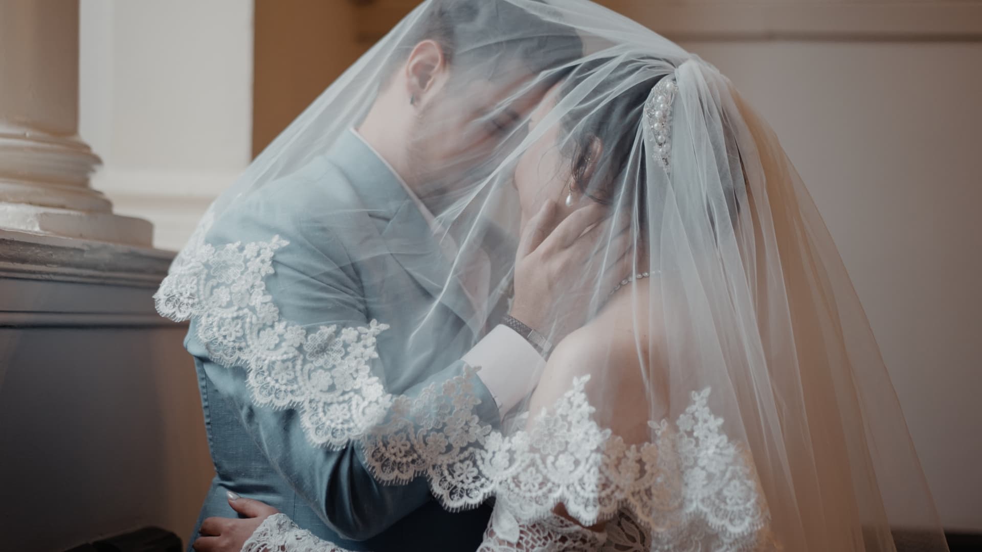 Bride and groom kiss beneath a lace veil in a cinematic documentary wedding film in Somerset