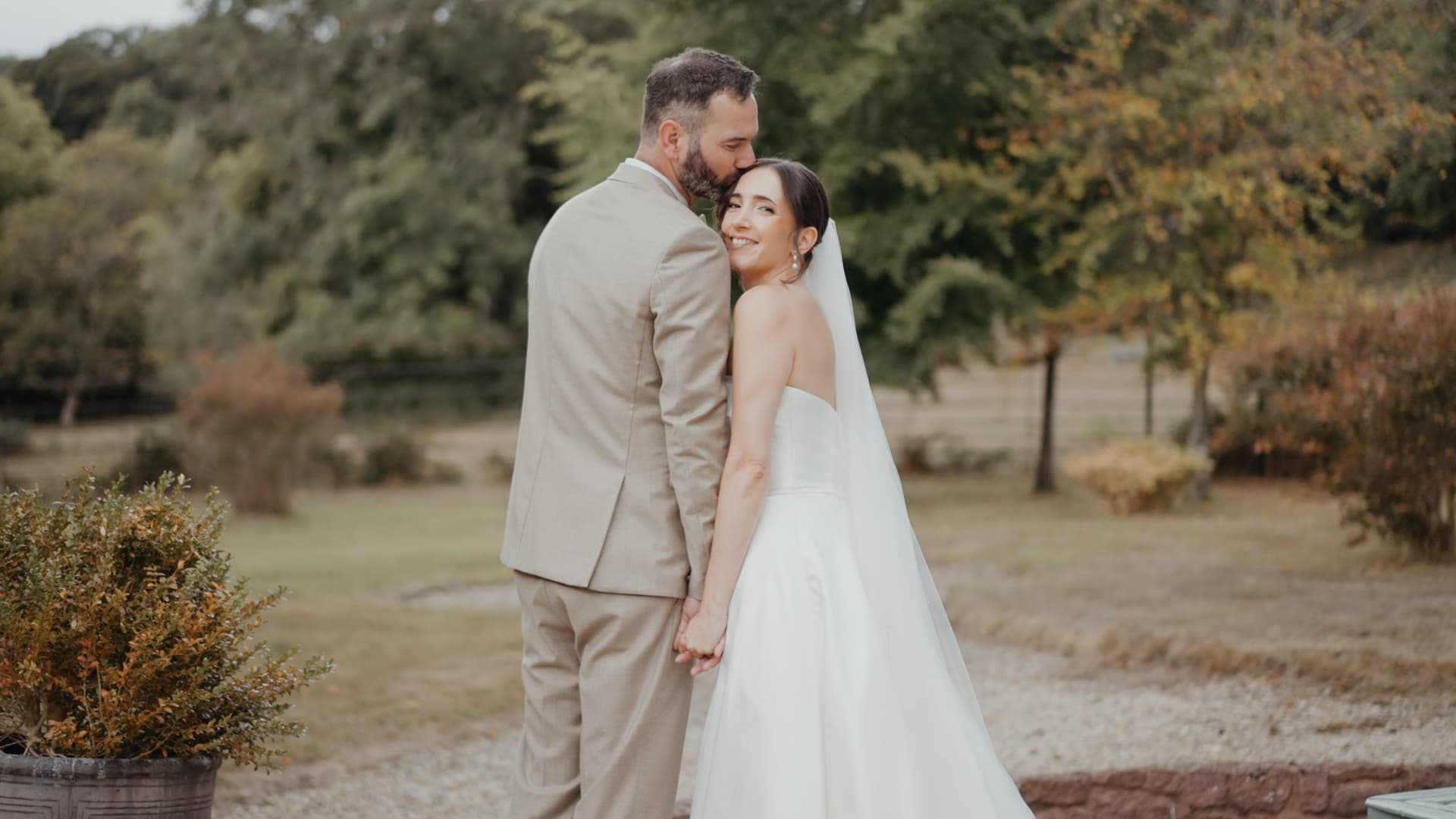 Groom kisses a smiling bride in a romantic portrait from a Somerset wedding videography package