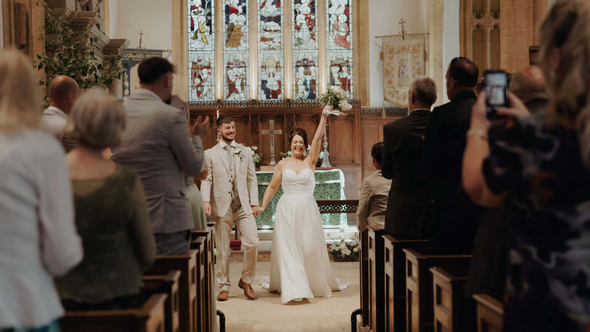 Newlyweds celebrate walking down the aisle at St George's Church, Hinton St George, after their ceremony